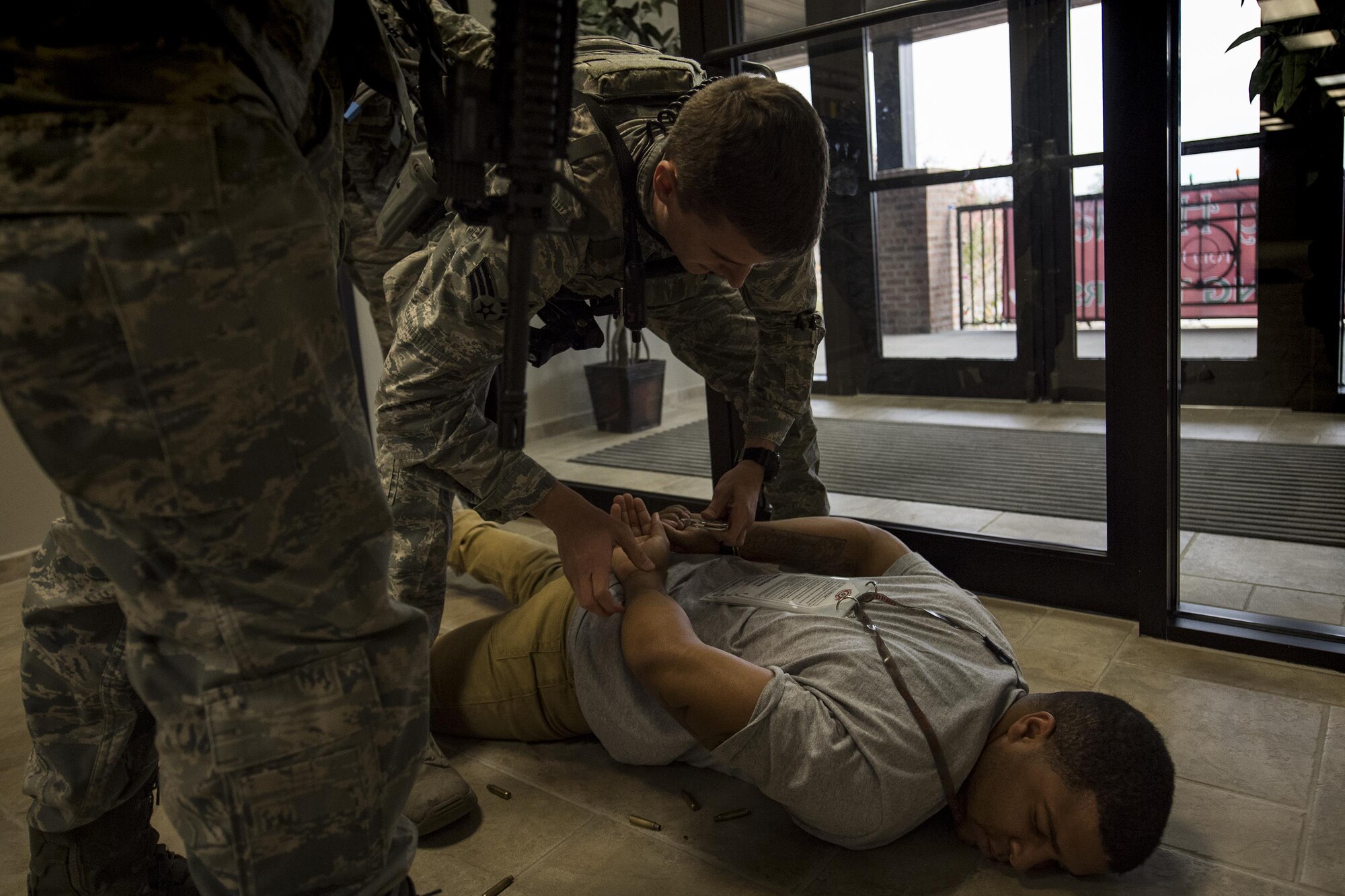 Members of the 23d Security Forces Squadron detain the simulated active shooter, U.S. Air Force Staff Sgt. Christopher Childress, 23d SFS military working dog trainer, during an active shooter exercise, Dec. 8, 2016, at Moody Air Force Base, Ga. The 23d SFS initially responded to the emergency and after securing the scene paramedics and firefighters assisted with simulated injured and deceased people. (U.S. Air Force photo by Airman 1st Class Daniel Snider) 