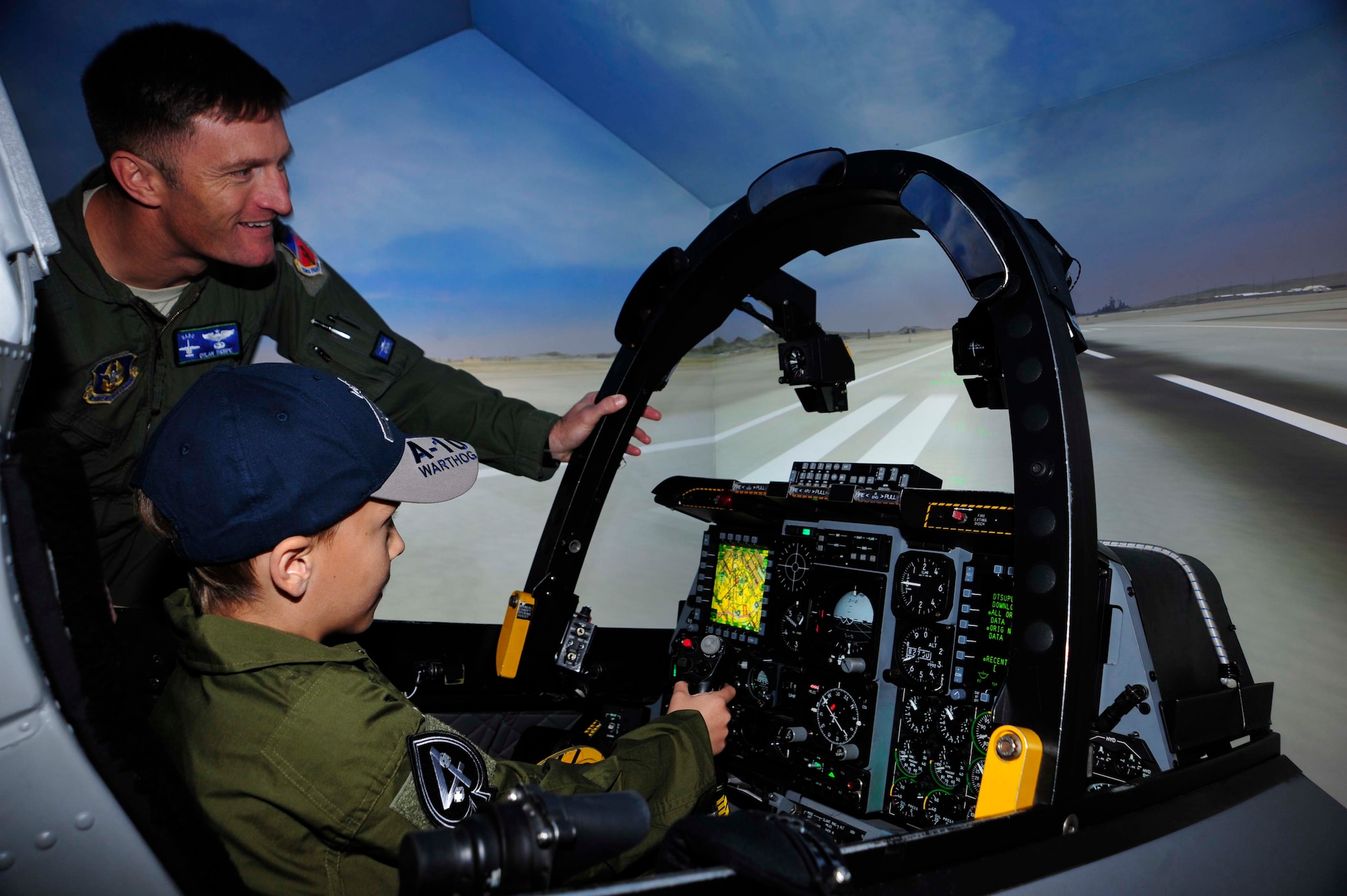 Noah Hepner, 10, is guided by Lt Colonel Dylan Thorpe, A-10C instructor pilot, as he takes off in the A-10C Thunderbolt II simulator during his visit to the 47th Fighter Squadron as part of the “Pilot for a Day” program at Davis-Monthan Air Force Base, Ariz., Dec. 4, 2016. Noah was diagnosed with High Risk Acute Lymphoblastic Leukemia, August 2015 and has two more years of treatment ahead of him. (U.S. Air Force photo by Tech. Sgt. Courtney Richardson)