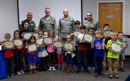 Team Charleston’s Storm Troopers, children who had parents on ride-out teams during Hurricane Matthew, hold up certificates for remaining calm, focused and ready during the storm with Joint Base Charleston leadership during a Storm Troopers ceremony at the Airman and Family Readiness Center here, Dec. 8, 2016. Nearly 23,000 base employees and their families evacuated Charleston Oct. 5, leaving a ride-out team of approximately 400 members to continue the base’s mission. 