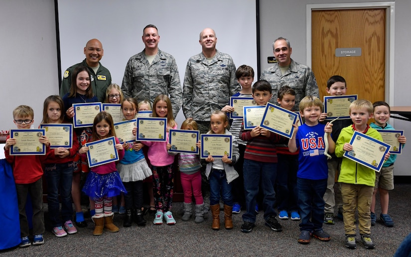 Team Charleston’s Storm Troopers, children who had parents on ride-out teams during Hurricane Matthew, hold up certificates for remaining calm, focused and ready during the storm with Joint Base Charleston leadership during a Storm Troopers ceremony at the Airman and Family Readiness Center here, Dec. 8, 2016. Nearly 23,000 base employees and their families evacuated Charleston Oct. 5, leaving a ride-out team of approximately 400 members to continue the base’s mission. 