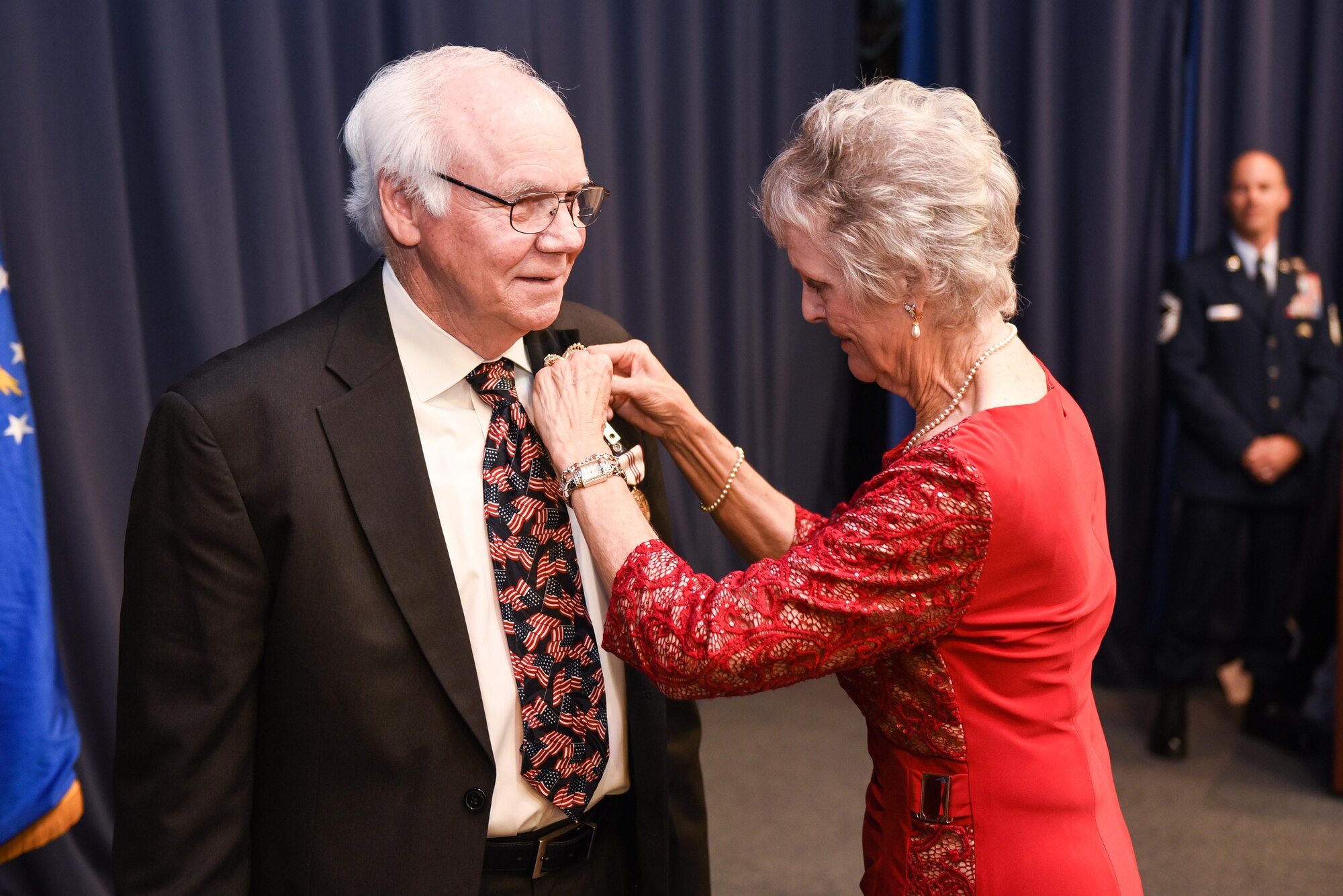 Lee McCallister, Jerry McCallister’s wife, pins on his retirement pin during his ceremony at Hurlburt Field, Fla., Dec. 9, 2016. McCallister retired from the civil service after 30 years. He also served 23 years on active duty bring his total service to the Air Force at 53 years. (U.S. Air Force photo by Senior Airman Jeff Parkinson)