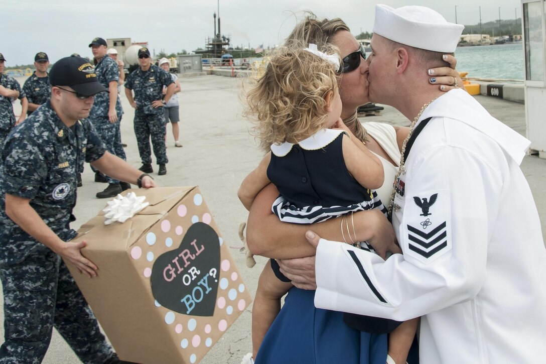 Navy Petty Officer 1st Class Jonathan Atkins kisses his wife, Jennifer, a during a homecoming celebration for the USS Oklahoma City in Apra Harbor, Guam, Dec. 8, 2016. The attack submarine returned to Guam after an eight-month maintenance period. Navy photo by Petty Officer 1st Class Jamica Johnson