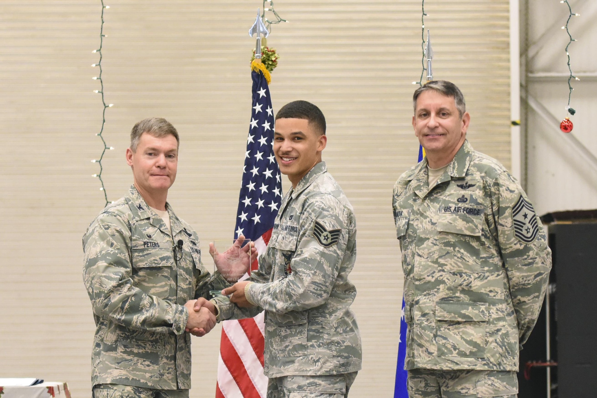 Staff Sgt. Brian E. Gordon, member of the 940th Civil Engineer Squadron, is presented with the award for NCO of the Quarter of the 940th Air Refueling Wing by Col. Craig C. Peters, 940 ARW commander, and Chief Master Sgt. Carmen Madia, 940 ARW command chief, during commander’s call Dec. 3, 2016, at Beale Air Force Base, California. During the commander’s call, many wing members were recognized for their achievements over the past year. (Air Force Photo by Staff Sgt. Brenda Davis)