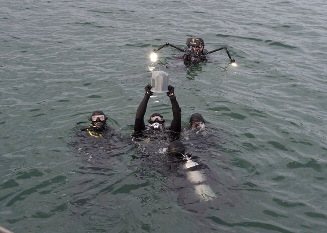 161207-N-ZK021-080 PEARL HARBOR (Dec. 7, 2016) Navy and National Park Service divers prepare ashes of John D. Anderson, boatswain’s mate 2nd class, for interment during a memorial ceremony and interment service at the Arizona Memorial. The 75th commemoration of the attack on Pearl Harbor and Oahu, co-hosted by the U.S. military, the National Park Service and the State of Hawaii, provided veterans family members, service members and the community a chance to honor the sacrifices made by those who were present Dec. 7, 1941, as well as throughout the Pacific theater. Since the attacks, the U.S. and Japan have endured more than 70 years of continued peace, a cornerstone of security and prosperity in the Indo-Asia-Pacific region. As a Pacific nation, the U.S. is committed to continue its responsibility of protecting the Pacific sea-lanes, advancing international ideals and relationships, as well as delivering security, influence and responsiveness in the region. (U.S. Navy Photo by Petty Officer 1st Class Nardel Gervacio/Released)