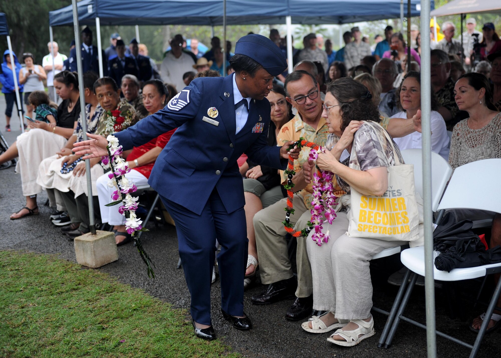 Master Sgt. Latersa Frazier, the superintendent of Pacific Air Forces protocol, assists family members of honored veterans as they present leis on a memorial during a commemoration ceremony at Bellows Air Force Station, Hawaii, Dec. 8th, 2016. Approximately 100 people, including family members of several honored veterans, came together in recognizing the bravery displayed at Bellows during the Dec. 7th attack on Pearl Harbor and Oahu. (U.S. Air Force photo by Staff Sgt. Alexander Martinez)
