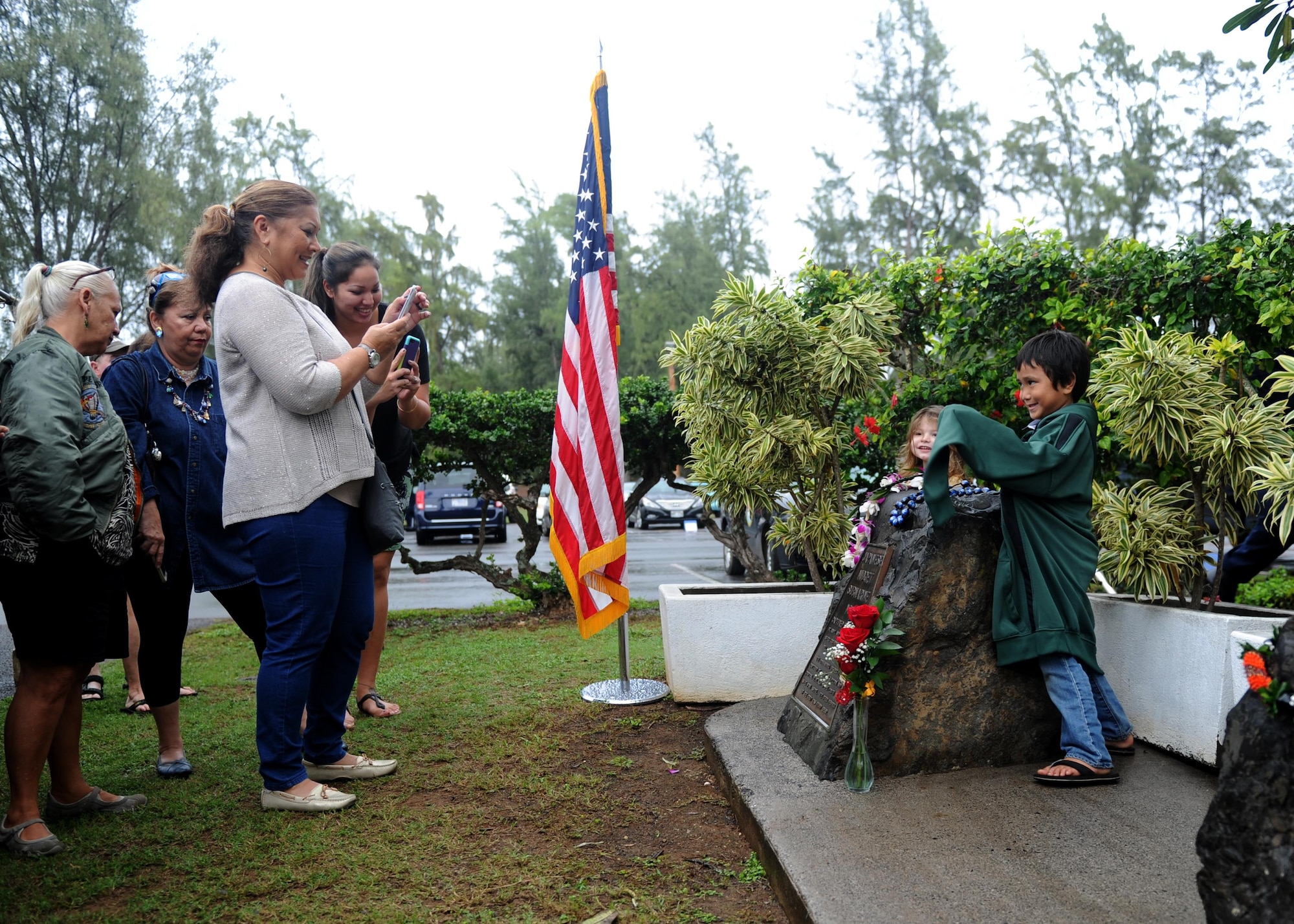 Family members of an honored veteran take photos of and with a memorial during a commemoration ceremony at Bellows Air Force Station, Hawaii, Dec. 8th, 2016. Approximately 100 people, including family members of several honored veterans, came together in recognizing the bravery displayed at Bellows during the Dec. 7th attack on Pearl Harbor and Oahu. (U.S. Air Force photo by Staff Sgt. Alexander Martinez)