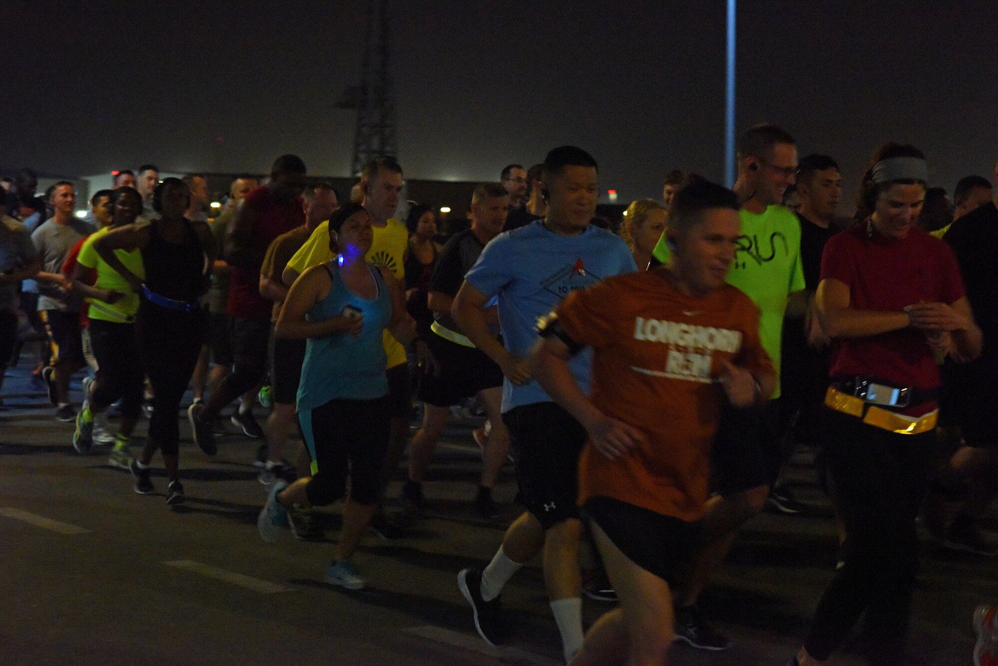 Base personnel dash through the starting line of a 5K race commemorating  the 75th anniversary of the attack on Pearl Harbor at Al Udeid Air Base, Qatar, Dec. 7, 2016. Participants used the anniversary as an opportunity to come together and honor the sacrifice and dedication of those who perished and those who survived the attack, both civilian and military. (U.S. Air Force photo by Senior Airman Cynthia A. Innocenti)