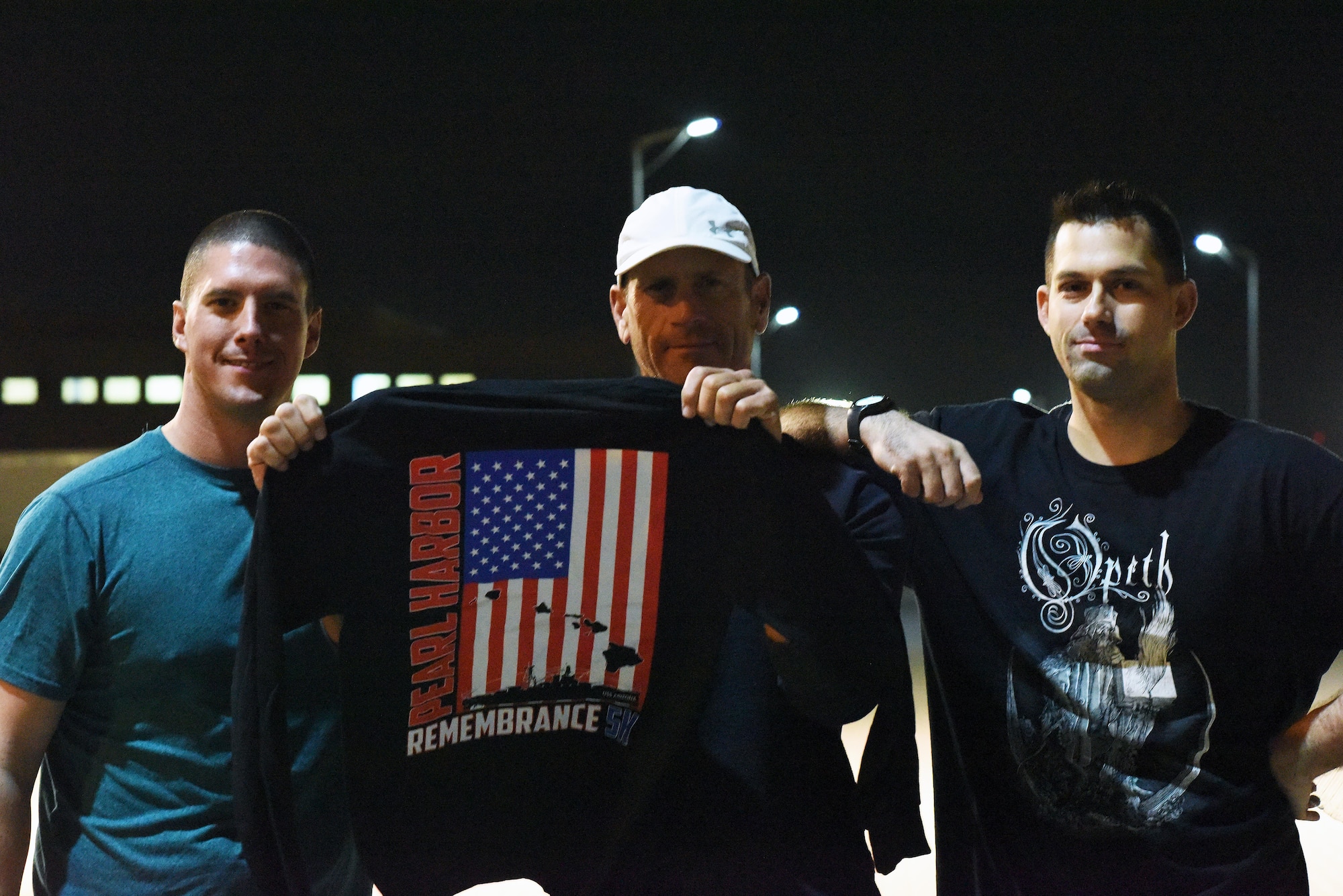 Airmen proudly showcase the T-shirt design for the Pearl Harbor Remembrance 5K held at Al Udeid Air Base, Qatar, Dec. 7, 2016. The specially designed T-shirt was given out to commemorate the 75th anniversary of the attack on Pearl Harbor. (U.S. Air Force photo by Senior Airman Cynthia A. Innocenti)