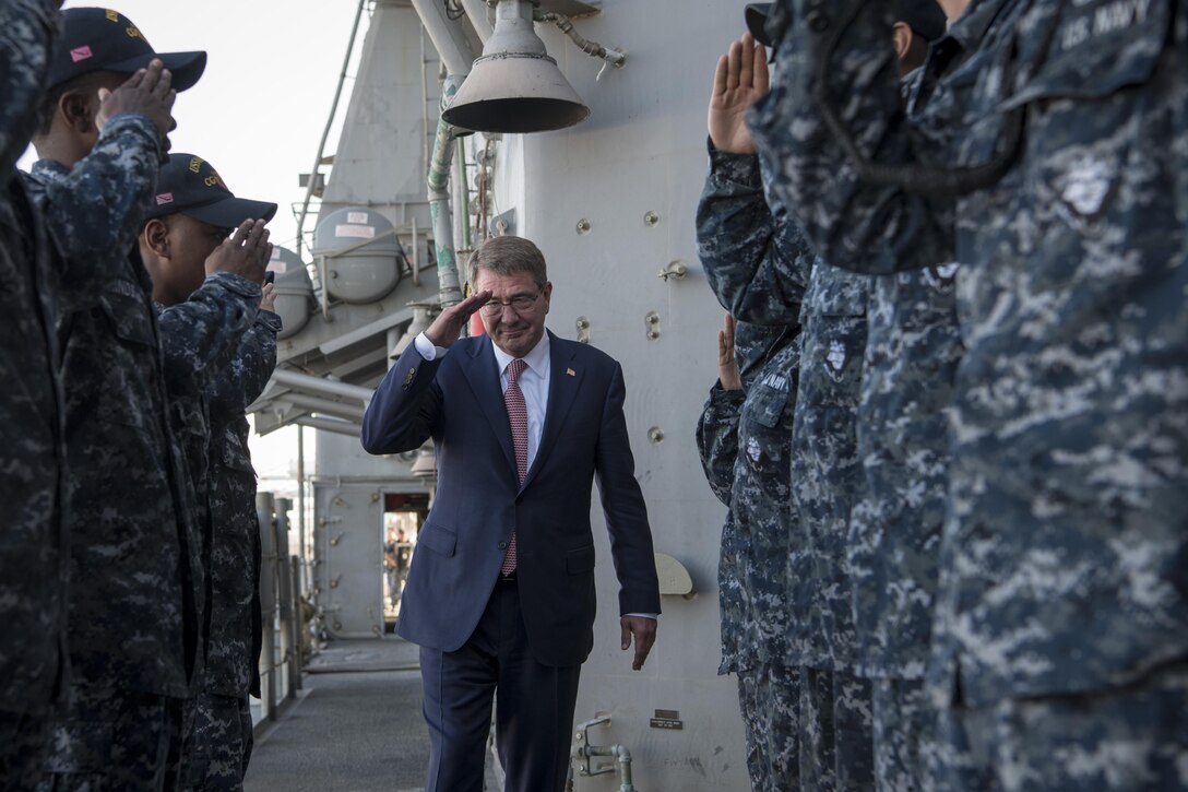 Defense Secretary Ash Carter salutes as he departs the USS Monterey.