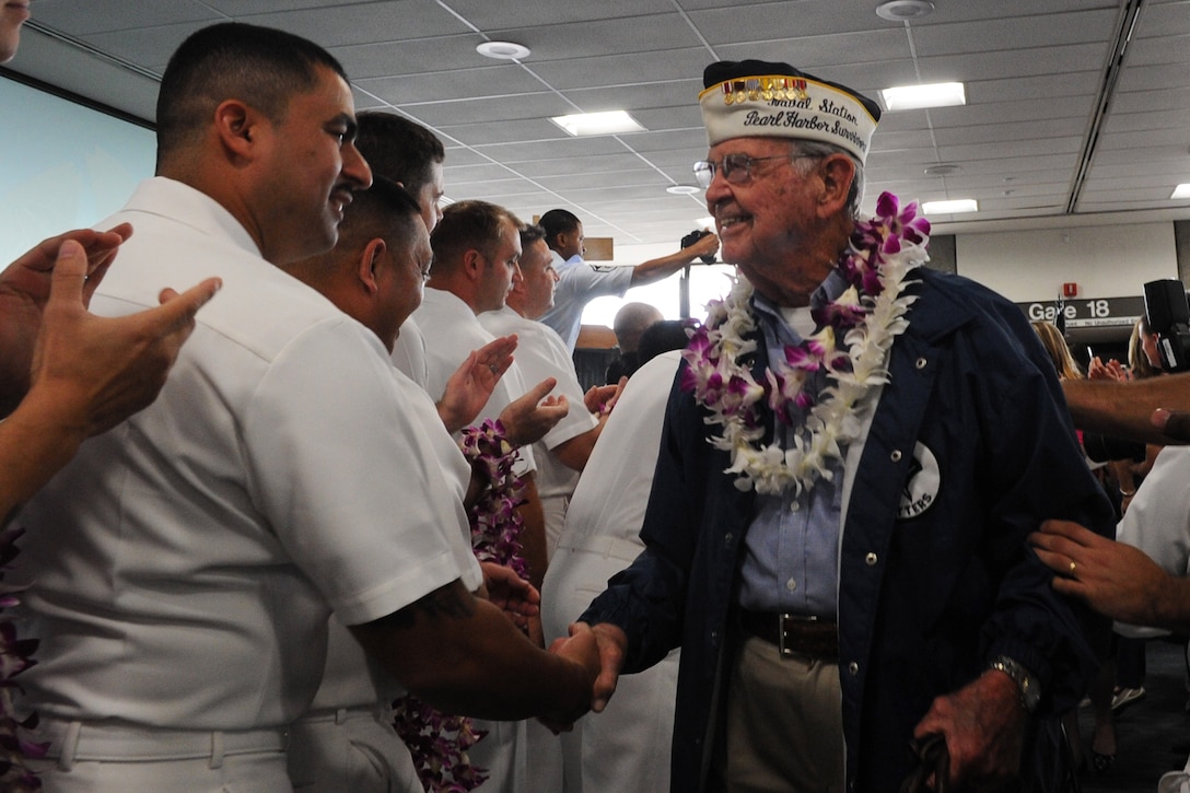 Retired Navy Capt. Bob Batterson is greeted by a sailor after arriving at Honolulu International Airport on an honor flight, Dec. 3, 2016. Batterson traveled from Los Angeles on the flight with more than 100 other World War II veterans for commemorations for the 75th anniversary of the attack on Pearl Harbor. DoD photo by Lisa Ferdinando