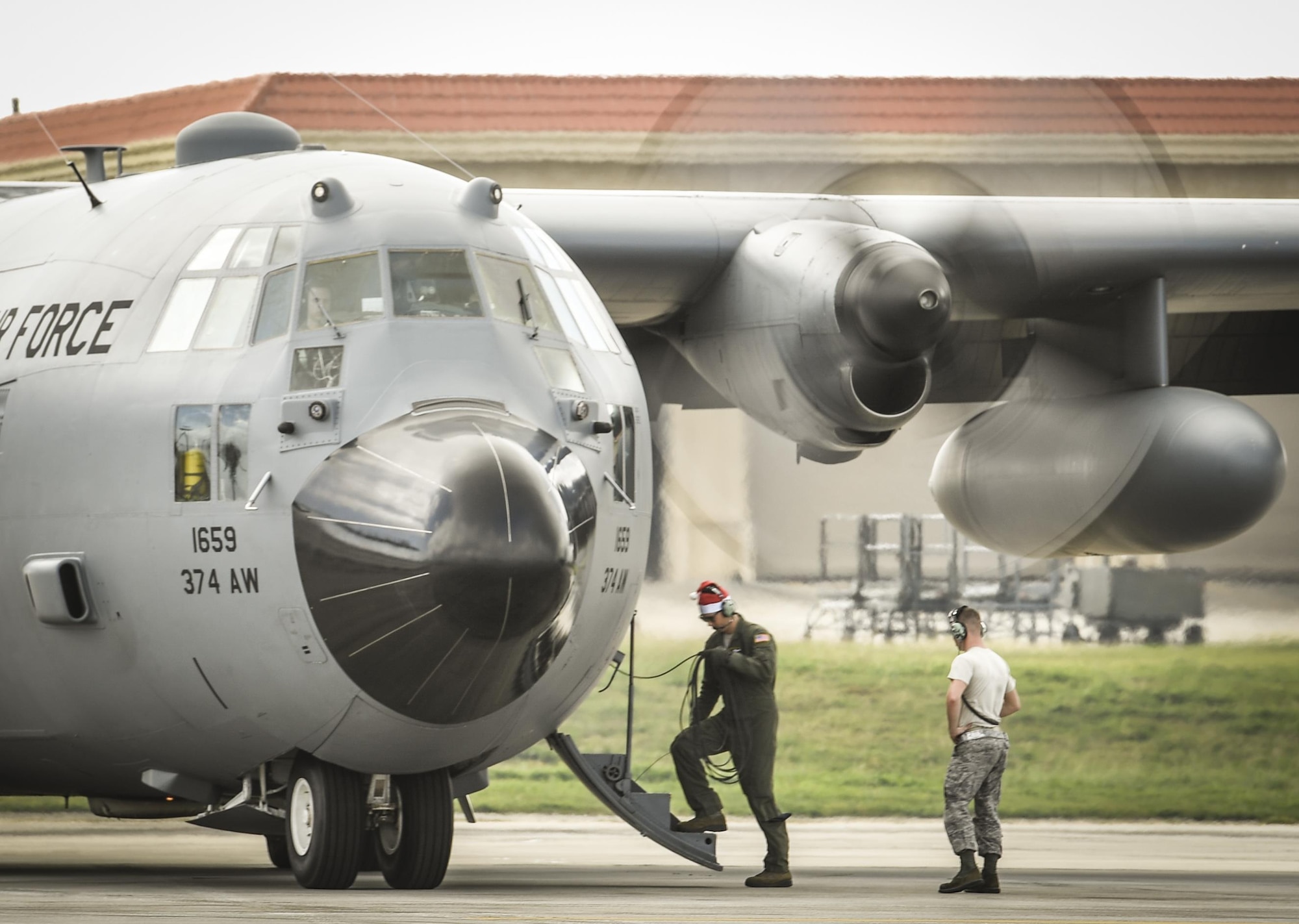 Senior Airman Anthony Schoof, left, 36th Airlift Squadron loadmaster, and Senior Airman Benjamin Campanella, 374th Maintenance Squadron crew chief, prepare a C-130 H Hercules for takeoff during Operation Christmas Drop at Andersen Air Force Base, Guam, Dec. 7, 2016. C-130s are ideal for performing air drops like those conducted during OCD because they are large enough to carry cargo and small enough to maneuver at relatively low altitudes. (U.S. Air Force photo by Senior Airman Elizabeth Baker/Released)