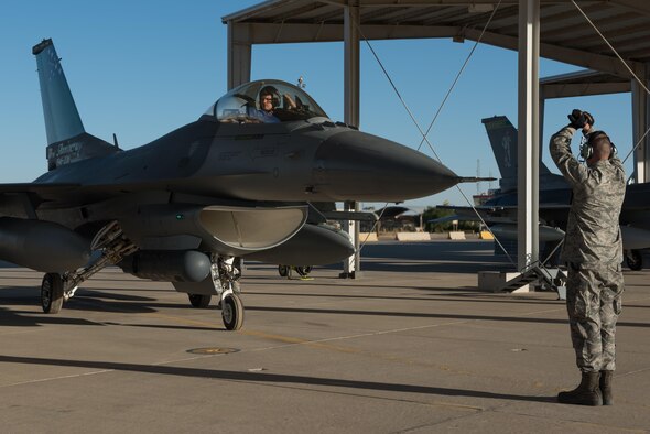 An crew chief with the 407th Expeditionary Aircraft Maintenance Squadron marshals an F-16 Fighting Falcon pilot with the 134th Expeditionary Fighter Squadron onto the ramp after arriving at the 407th Air Expeditionary Group, Southwest Asia, Dec. 10, 2016. About 300 Airmen from the 158th Fighter Wing of the Vermont Air National Guard arrived in the past few days to support the F-16 mission here. (U.S. Air Force photo by Master Sgt. Benjamin Wilson)