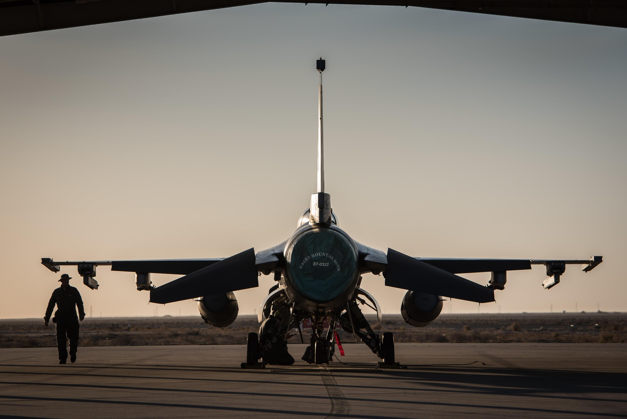 A crew chief with the 407th Expeditionary Aircraft Maintenance Squadron walks past an F-16 Fighting Falcon assigned to the 134th Expeditionary Fighter Squadron at the 407th Air Expeditionary Group, Southwest Asia, Dec. 10, 2016. About 300 Airmen from the 158th Fighter Wing of the Vermont Air National Guard comprise the units. (U.S. Air Force photo by Master Sgt. Benjamin Wilson)