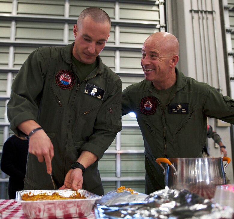 U.S. Marine Corps Staff Sgt. Sean Dee, left, the Aircraft Rescue and Firefighting station captain, and Gunnery Sgt. Matthew Viehl, assistant chief of operations at ARFF, prepare to serve food for the ARFF Tsuta Orphanage Christmas party at Marine Corps Air Station Iwakuni, Japan, Dec. 10, 2016. ARFF holds the party annually to help spread Christmas cheer to the orphans and to bring service members, their families and the Japanese together. Marines volunteered their time and provided the children with a homemade, American meal. (U.S. Marine Corps photo by Lance Cpl. Gabriela Garcia-Herrera)