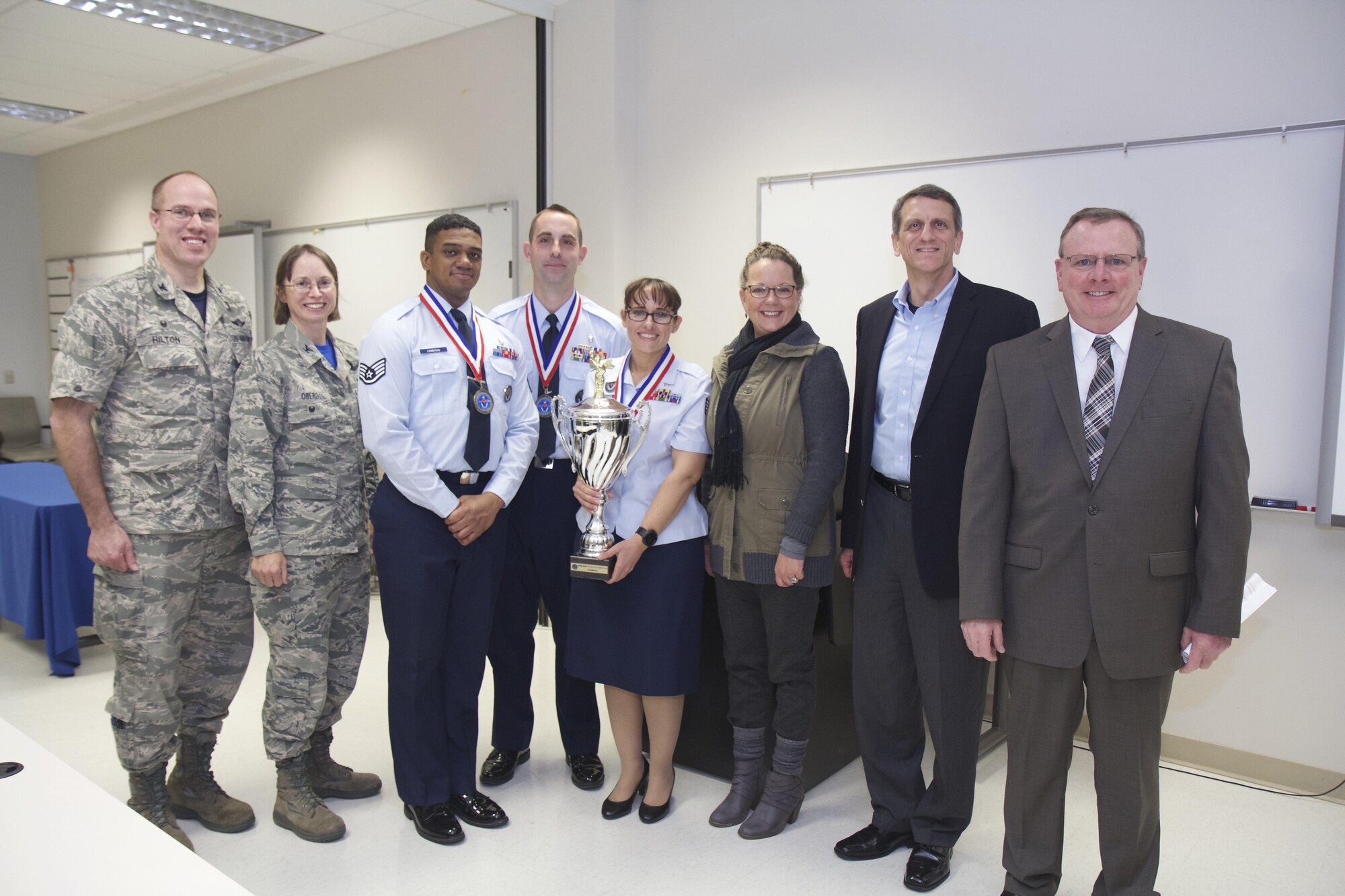 Col. Alden Hilton, commander of the 711th Human Performance Wing's U.S. Air Force School of Aerospace Medicine, poses with the judges and winners of the school's third annual SAM-Tastic instructional excellence competition. Left to right are: Hilton; Col. Elena Oberg, 88th Air Base Wing vice commander and SAM-Tastic judge; Staff Sgt. Christopher Cameron, USAFSAM Occupational and Environmental Health Department instructor; Staff Sgt. Jonathan Cavier, USAFSAM Occupational and Environmental Health Department instructor; Staff Sgt. Barbara Rucker, USAFSAM Occupational and Environmental Health Department instructor; Tammy Bugher, Air Force Institute of Technology School of Systems and Logistics director of Instructional Systems and SAM-Tastic judge; Tim Sakulich, 711 HPW vice director and SAM-Tastic judge; and John Duren, SAM-Tastic program manager. (U.S. Air Force photo/David Snedigar)