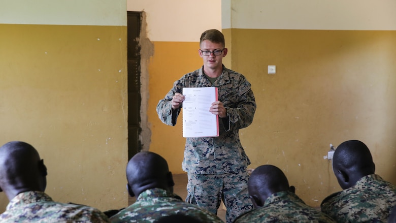 Cpl. Timothy Dykes, a communications advisor with Special Purpose Marine Air-Ground Task Force Crisis Response-Africa, shows soldiers with the Uganda People’s Defense Force a radio frequencies chart at Camp Singo, Uganda, Nov. 14, 2016. Marines with SPMAGTF-CR-AF taught classes and participated in practical application exercises with UPDF soldiers during the nine-week training mission. 
