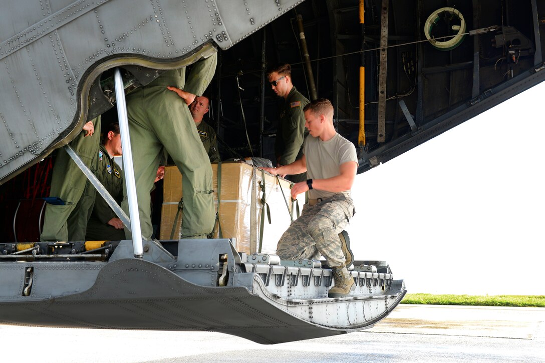 Airmen prepare a humanitarian aid bundle aboard an Air Force C-130 Hercules at Andersen Air Force Base, Guam, Dec. 5, 2016. Air Force photo by Senior Airman Elizabeth Baker
