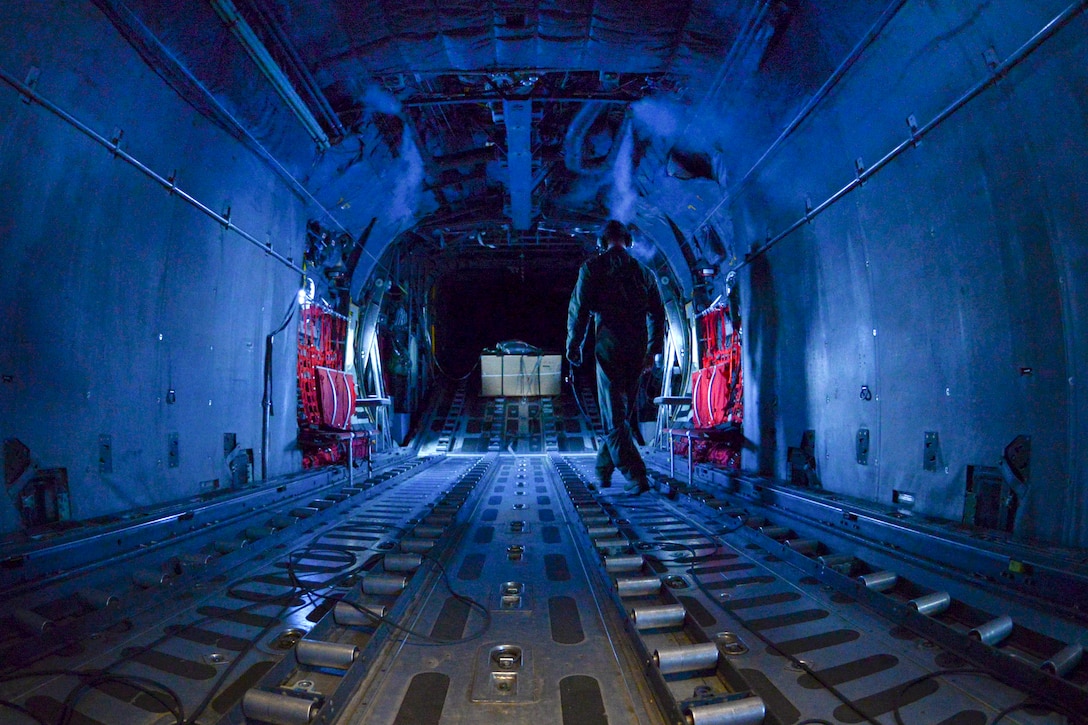 Air Force Staff Sgt. Timothy Johnson walks the cargo hold inside a C-130 Hercules during Operation Christmas Drop over the Micronesian islands, Dec. 5, 2016. Johnson is a loadmaster assigned to the 36th Airlift Squadron. Air Force photo by Senior Airman Elizabeth Baker