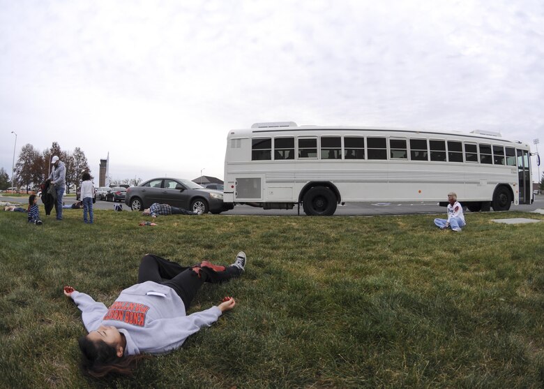 Volunteers get in position during a total force mass casualty exercise at Whiteman Air Force Base, Mo., Dec. 3, 2016. More than 40 volunteers acted like they were family members riding in a bus to the flightline to see their deployers off when a car hit the back of the bus and detonated a radiological dispersible device. (U.S. Air Force photo/Senior Airman Missy Sterling)