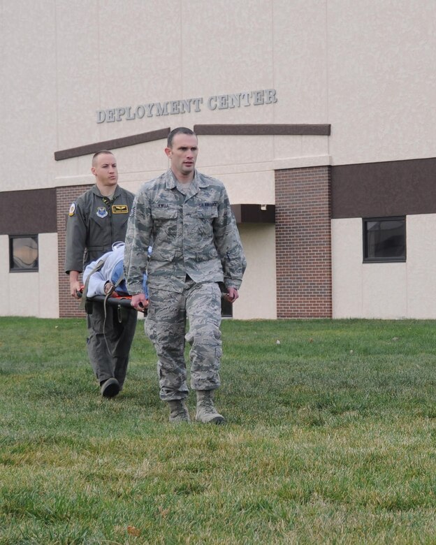 U.S. Air Force Capt. Andrew Schaar and Staff Sgt. Merlin Jewell, medical personnel assigned to the 393rd Bomb Squadron, carry a volunteer simulating a severe injury during a total force mass casualty exercise at Whiteman Air Force Base, Mo., Dec. 3, 2016. Emergency personnel arrived on the scene, triaged the victims and transported them to the clinic to be decontaminated and treated. (U.S. Air Force photo/Senior Airman Missy Sterling)