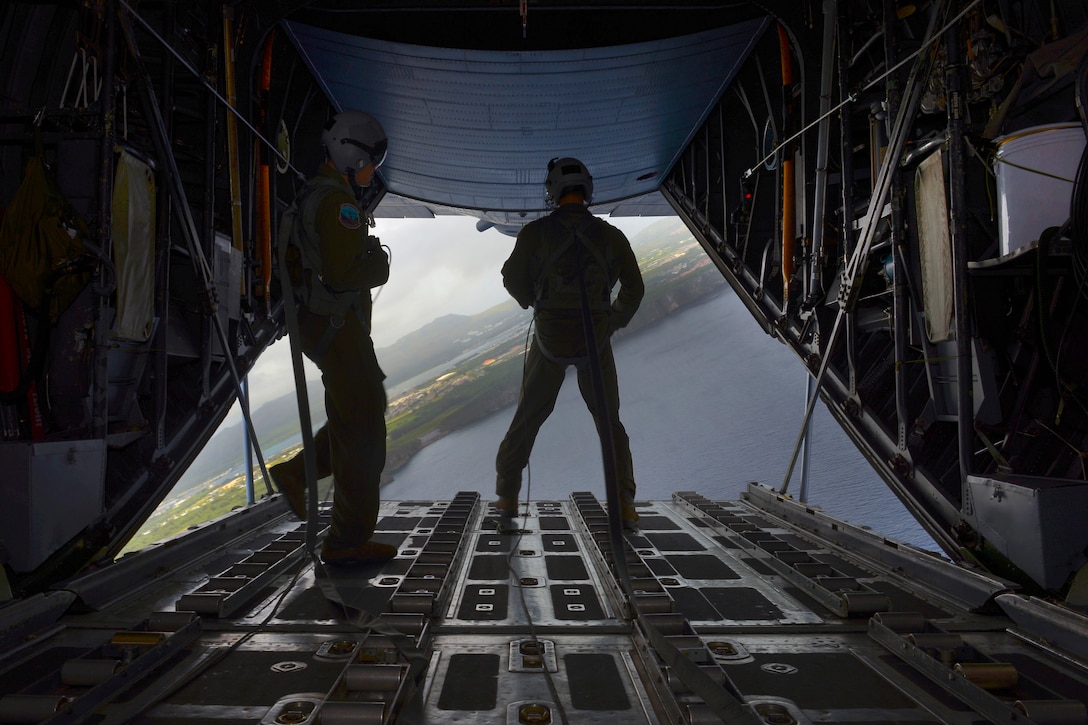 Air Force Staff Sgt. Timothy Johnson, right, and Senior Airman Anthony Schoof look out of the back of a C-130 Hercules during Operation Christmas Drop over the Micronesian islands, Dec. 5, 2016. Johnson and Schoof are loadmasters assigned to the 36th Airlift Squadron. Air Force photo by Senior Airman Elizabeth Baker