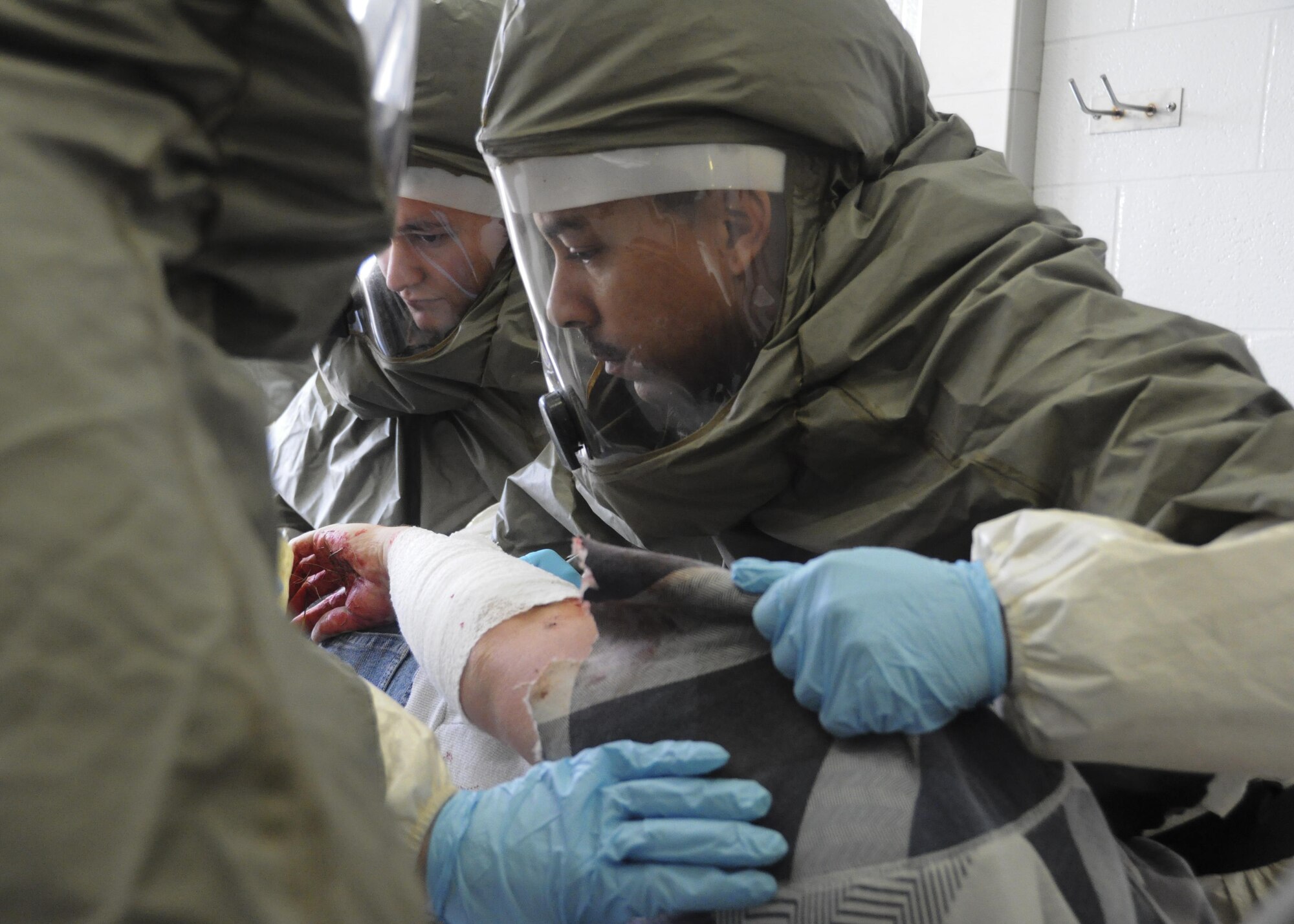 U.S. Air Force Airman 1st Class Chris Stangl, right, a public health technician, and Senior Airman Dylan Kielcheski, an aerospace medical technician, both with the 509th Medical Operations Squadron, help hold a volunteer victim on their side to decontaminate all areas of the victim during a total force mass casualty exercise at Whiteman Air Force Base, Mo., Dec. 3, 2016. Volunteer victims were brought through a decontamination line before being admitted into the clinic. (U.S. Air Force photo/Senior Airman Missy Sterling)