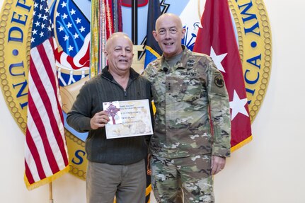 Edelmiro Fonseca, U.S. Army Reserve Command G-38 Resource Management, is presented his first place award for his cubicle decoration by LTG Charles D. Luckey, Chief, U.S. Army Reserve and Commanding General, U.S. Army Reserve Command, smiles after lighting the Christmas tree during the USARC Holiday Open House and Tree Lighting ceremony, Dec. 9, 2016. USARC Soldiers and civilians took time out to celebrate the season and fellowship with each other. (U.S. Army photo by Timothy L. Hale/Released)