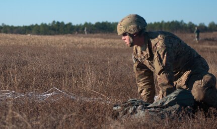 U.S. paratrooper, Sgt. Jared Jarvis representing C Battery, 3-319th squadron gathers his parachute after jumping from C-130 during Operation Toy Drop XIX Dec. 9 at Luzon drop zone at Camp Mackall, N.C. Sgt. Jarvis is one of 4,000 paratroopers participating in OTD XIX. OTD is the world’s largest annual joint and combined airborne operation and collective training. (U.S. Army Reserve photo by Spc. Tynisha L. Daniel)