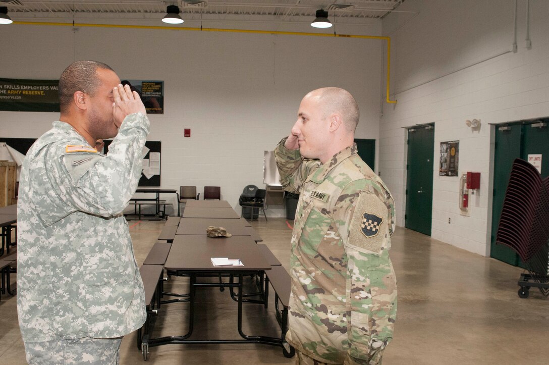 Maj. Jaison Bloom (left), the 326th MPAD Commanding Officer, salutes Capt. Dustin Gabus during a promotion ceremony Saturday, Dec. 10, at the U.S. Army Reserve Center in Reading Pa. Gabus will continue to serve as a Public Affairs Officer with the 214th MPAD located in Richmond, VA.