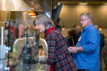 Jean Boyko looks at the available lunch choices while her spouse Dr. Greg Boyko, 60th Medical Group honorary commander, Travis Air Force Base, Calif., looks on during their tour of the Travis dining facility, Dec. 2, 2016. The purpose of the Travis Honorary Commander Program is to promote relationships between base senior leadership and civilian partners, foster civic appreciation of the Air Force mission and its Airmen, maximize opportunities to share the Air Force story with new stewards, and communicate mutual interest, challenges, and concerns that senior leaders and civilian stakeholders have in common. (U.S. Air Force photo/Louis Briscese)