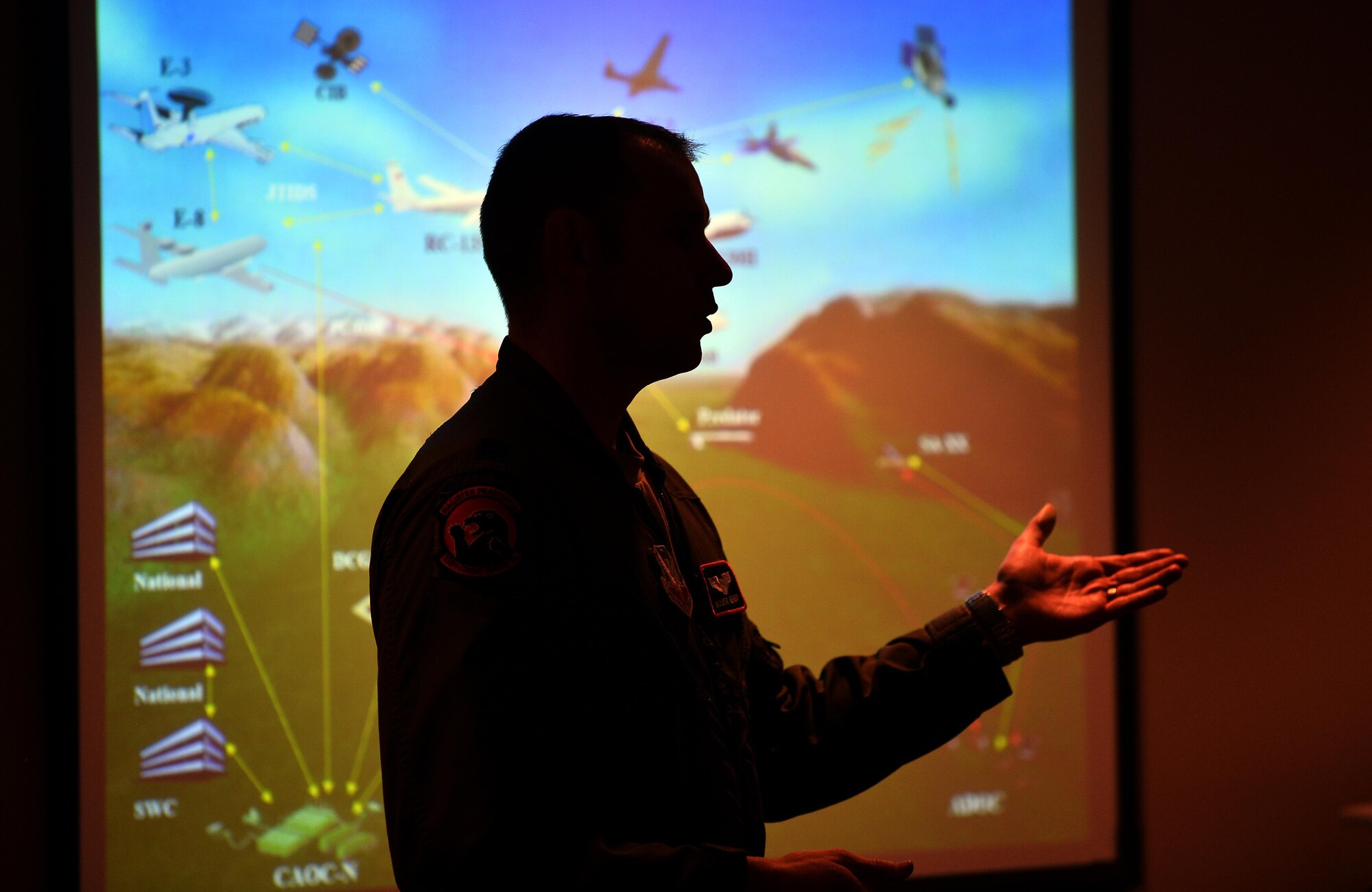 Capt. Tim Kenny, Chief of Central Flight Instructors Course with the 338th Combat Training Squadron, gives a briefing to military spouses as to the overall mission of the 55th Wing during a Spouse Appreciation Night held Dec. 7, 2016, at Offutt Air Force Base, Neb. Following the briefing, spouses were given the chance to pilot a flight simulator before getting to tour one of the aircraft associated with the wing. (U.S. Air Force photo by Josh Plueger)