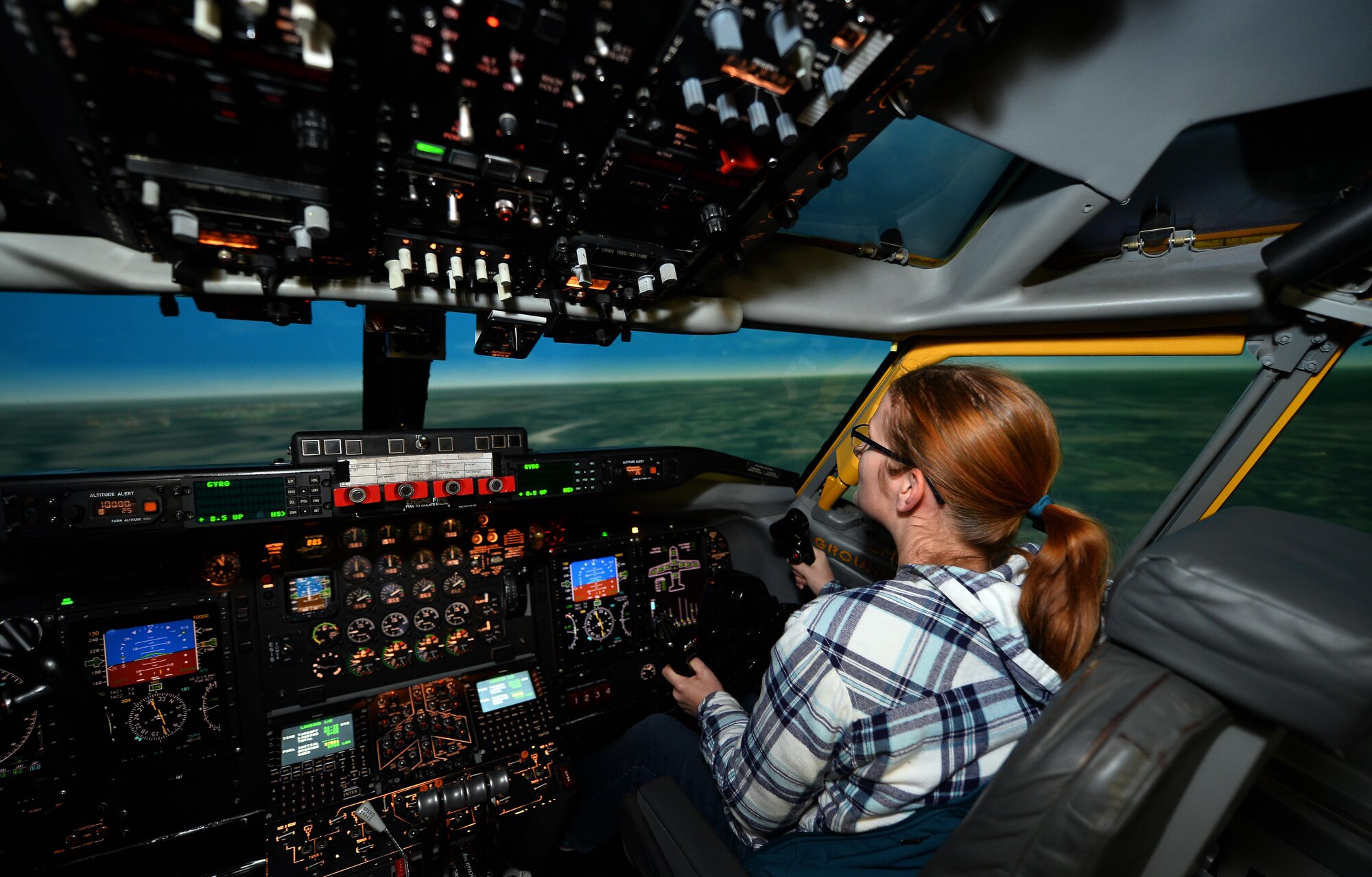 Chelsea Day, wife of Capt. Michael Day with the 55th Operational Support Squadron, pilots an Operational Flight Trainer simulator as part of a Spouse Appreciation Night held Dec. 7, 2016, at Offutt Air Force Base, Neb. The OFT3 simulator provides realistic flight training for pilots prior to piloting the different aircraft at Offutt AFB. (U.S. Air Force photo by Josh Plueger)