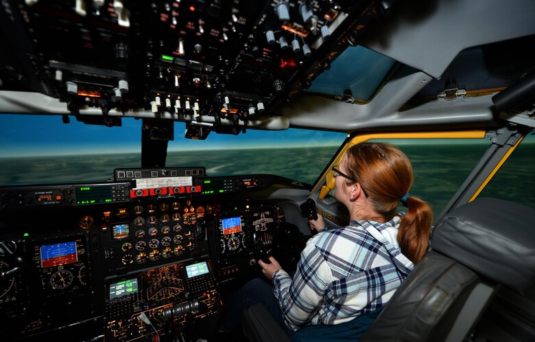 Chelsea Day, wife of Capt. Michael Day with the 55th Operational Support Squadron, pilots an Operational Flight Trainer simulator as part of a Spouse Appreciation Night held Dec. 7, 2016, at Offutt Air Force Base, Neb. The OFT3 simulator provides realistic flight training for pilots prior to piloting the different aircraft at Offutt AFB. (U.S. Air Force photo by Josh Plueger)