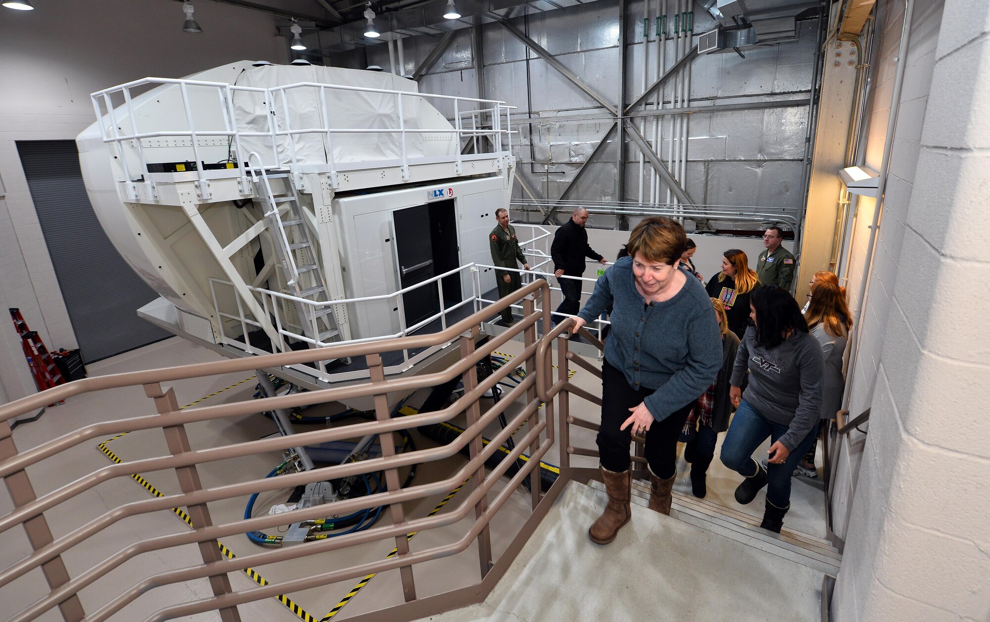Spouses of military Airmen exit the Operational Flight Trainer simulator, as part of a Spouse Appreciation Night held Dec. 7, 2016, at Offutt Air Force Base, Neb. The OFT3 simulator provides a variety of realistic simulations to test new pilots and navigators prior to flying a real RC-135 aircraft. (U.S. Air Force photo by Josh Plueger)