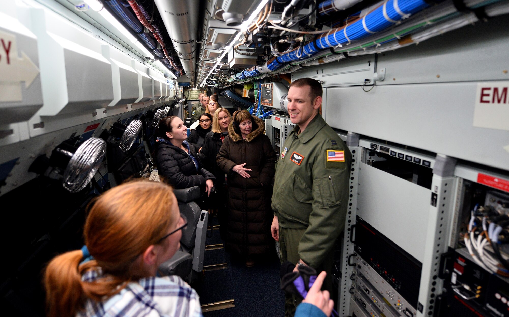 Capt. Tim Kenny, Chief of Central Flight Instructors Course with the 338th Combat Training Squadron, answers questions from military spouses touring an RC-135 Aircraft parked in a hangar of the Bennie Davis Maintenance Facility as part of Spouse Appreciation Night, Dec. 7, 2016, at Offutt Air Force Base, Neb. This was the first, of many, wing spouse tours.  The tour itinerary began with a briefing followed by a state-of-the-art flight simulator and ending with an aircraft tour. (U.S. Air Force photo by Josh Plueger)