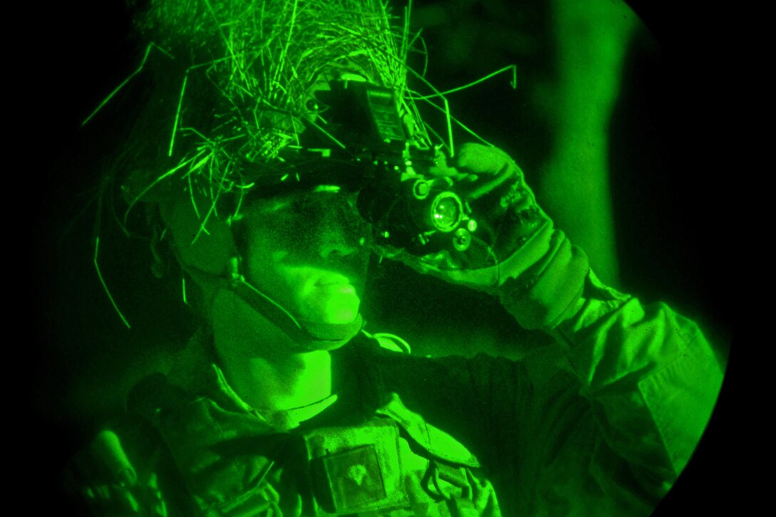A soldier adjusts his night goggles to observe team members on the battlefield during a night live-fire exercise as part of Exercise Mountain Shock at Pocek Range in Slovenia, Dec. 5, 2016. Army photo by Paolo Bovo