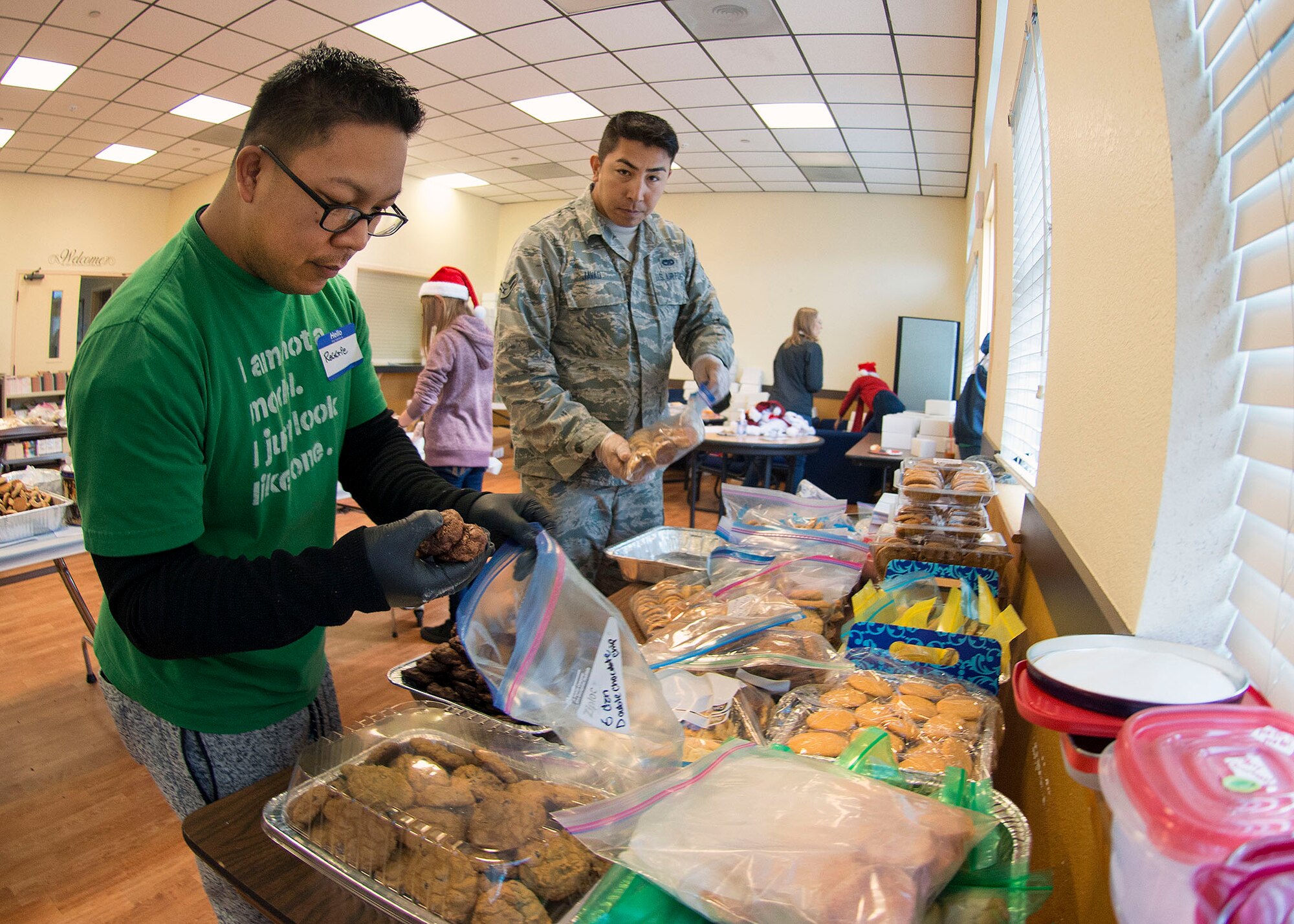 Tech. Sgt. Reginald Pascua (Left), and Airman 1st Class Mohammad Javad (Right), both members of the 60th Aerial Port Squadron, separate cookies inside the First Street Chapel at Travis Air Force Base, Calif., Dec. 7, 2016, before they are boxed up and gift wrapped for delivery to Airmen across Travis. Hundreds of volunteers participated in this year’s ‘Operation Cookie Drop’ by baking, sorting, packaging and delivering thousands of cookies.  A combination of service and family members, retirees and local citizens made this year’s event a success. (U.S. Air Force Photo/T.C. Perkins Jr.)