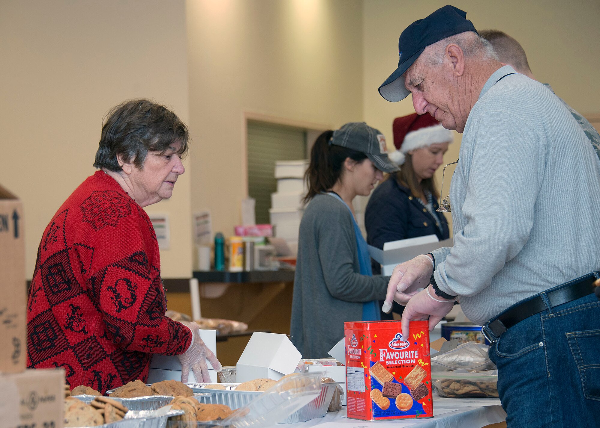 Ida Aqulina and her husband, retired U.S. Navy Commander Fred Aquilina, sort and box cookies during Operation Cookie Drop at Travis Air Force Base, Calif., Dec. 7, 2016. The couple has supported the annual event since 2005 and joined hundreds of volunteers this year. Volunteers helped bake, sort, package and deliver thousands of cookies to Travis Airmen. (U.S. Air Force Photo/T.C. Perkins Jr.)