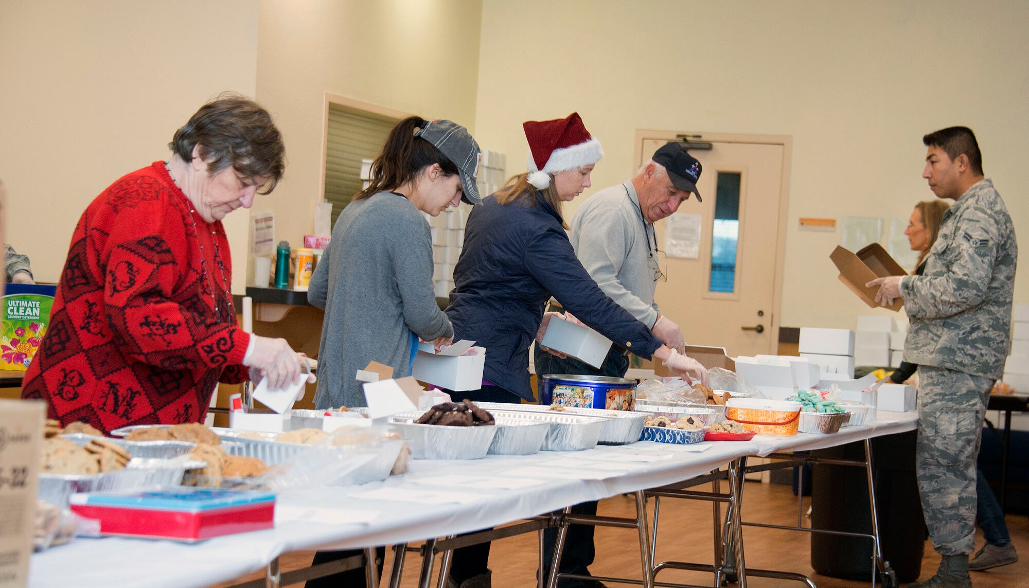 Several volunteers separate cookies into individual gift boxes inside the First Street Chapel at Travis Air Force Base, Calif., during Operation Cookie Drop Dec. 7, 2016. Hundreds of volunteers participated in this year’s event by baking, sorting, packaging and delivering thousands of cookies to Travis Airmen.      (U.S. Air Force Photo/T.C. Perkins Jr.)