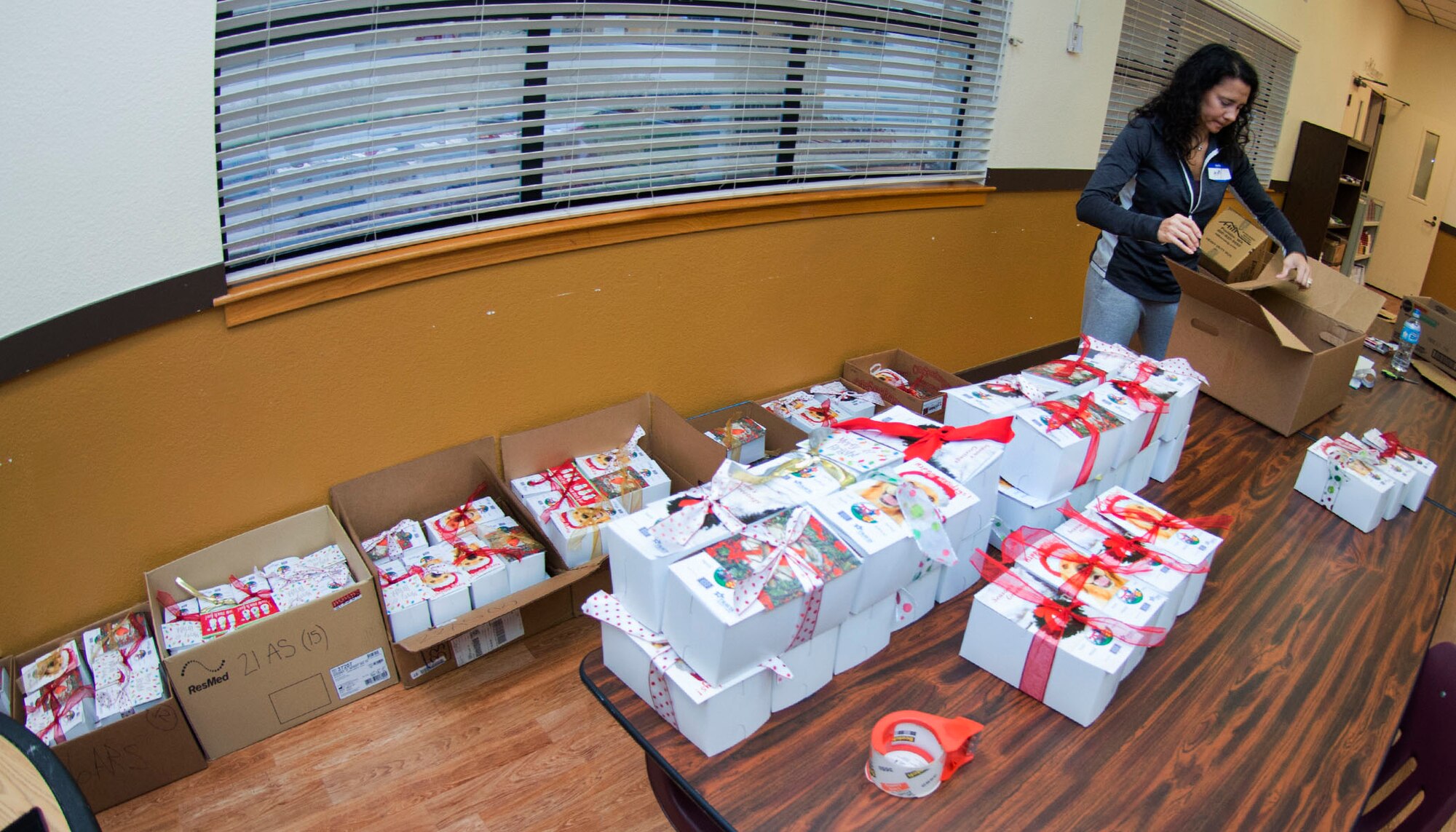 Amy Marcum prepares gift boxes of cookies for delivery inside the First Street Chapel at Travis Air Force Base, Calif., Dec. 7, 2016 during Operation Cookie Drop. Hundreds of volunteers participated in this year’s event by baking, sorting, packaging and delivering thousands of cookies to Travis Airmen. (U.S. Air Force Photo/T.C. Perkins Jr.)