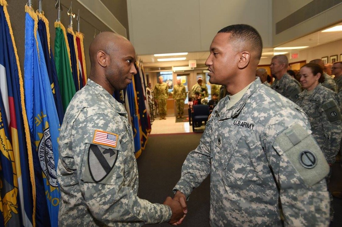 Army Reserve Staff Sgt. Martel Bowen, left, shakes hands with Staff Sgt. Roje Rogers immediately following a promotion ceremony for Rogers during the 85th Support Command's battle assembly weekend training, Dec. 3, 2016.
(Photo by Sgt. Aaron Berogan)