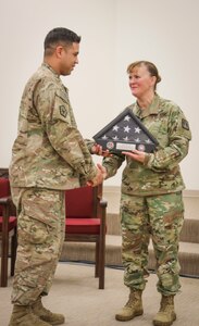 Army Reserve Staff Sgt. Mathew J. Tolbe, an information technology specialist from Waianae, Hawaii, assigned to Detachment 10, 335th Signal Command (Theater) receives a Welcome Home Warrior flag and display case from Brig. Gen. Nikki Griffin-Olive, deputy commanding general of sustainment, 335th SC (T) during a welcome home warrior ceremony at the North Fort Hood Chapel Dec. 11.  Tolbe and nearly 70 other Army Reserve Soldiers from Det. 10 recently returned from a nine month deployment to Kuwait in support of Operations Freedom Sentinel and Spartan Shield.