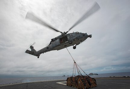 In this file photo,  an MH-60S Sea Hawk, assigned to Helicopter Sea Combat Squadron (HSC) 25, picks up cargo pallets from the flight deck of amphibious assault ship USS Bonhomme Richard (LHD 6) during a replenishment at sea (RAS), Sept. 22, 2016. Bonhomme Richard, flagship of the Bonhomme Richard Expeditionary Strike Group, is operating in the Philippine Sea in support of security and stability in the Indo-Asia Pacific region.