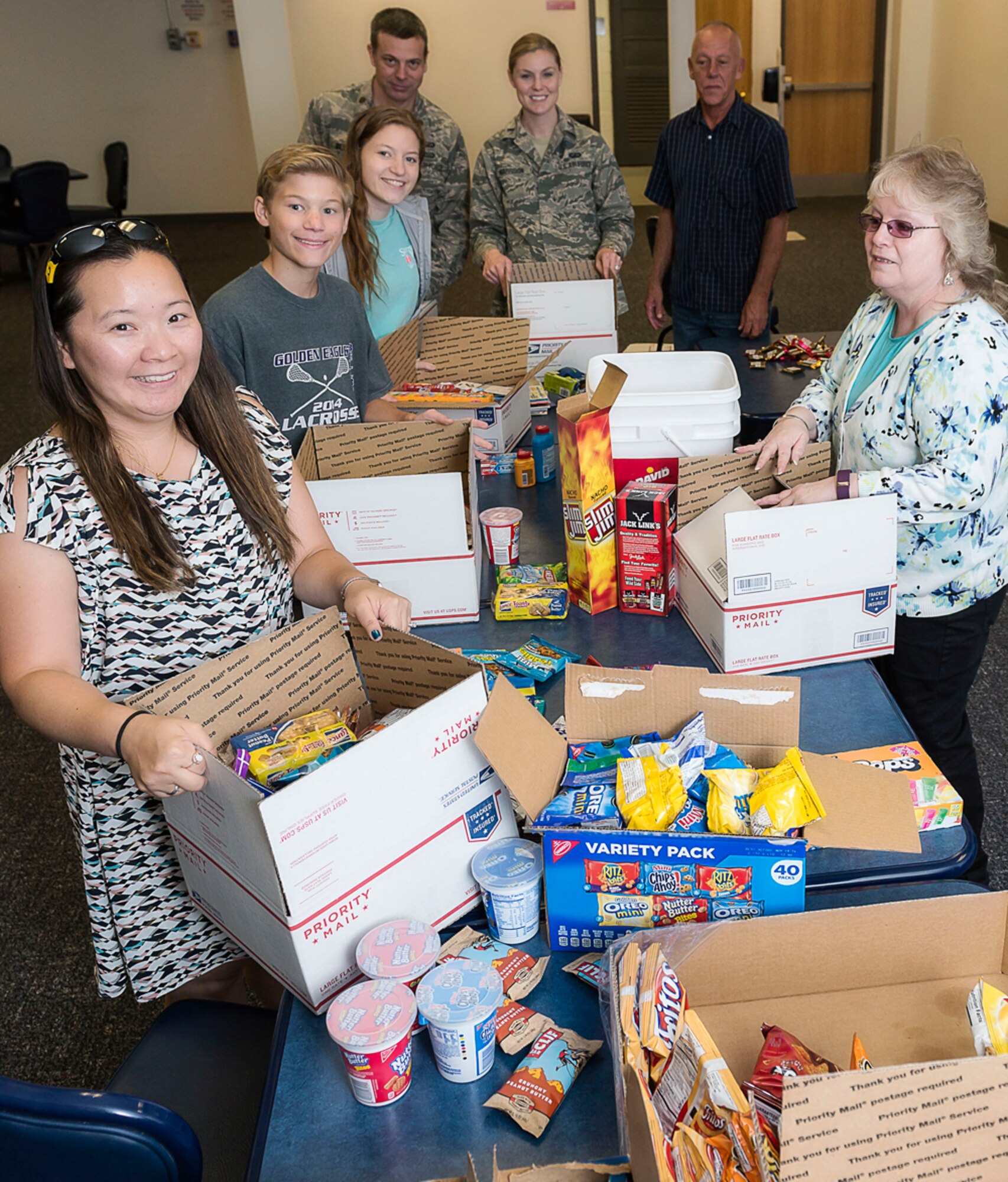 Key spouses and their family members, along with staff from Air Force Research Laboratory’s Operations Support Office, assemble care packages for 20 deployed AFRL team members. (U.S. Air Force photo / Alaina Fitzner)