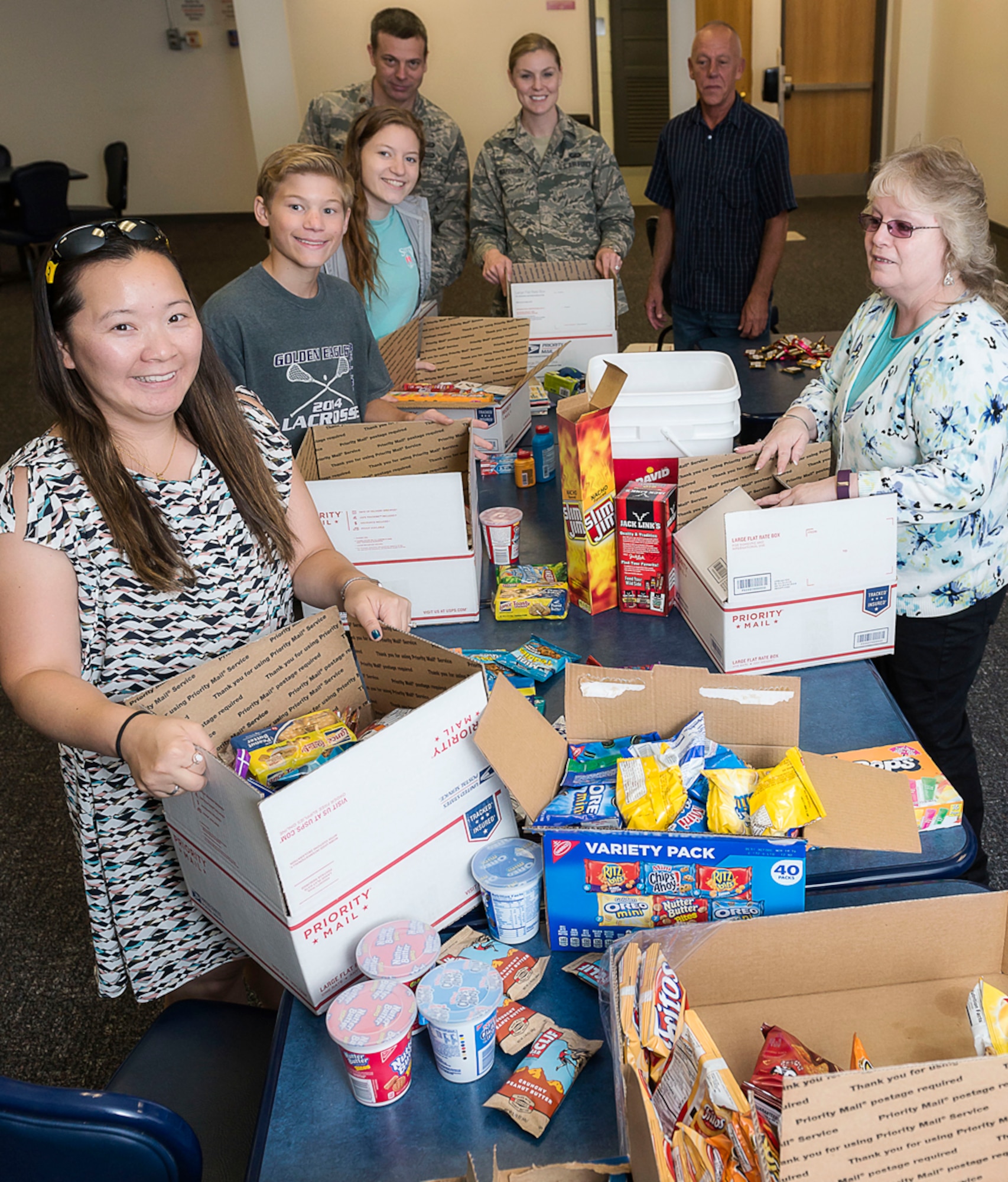 Key spouses and their family members, along with staff from Air Force Research Laboratory’s Operations Support Office, assemble care packages for 20 deployed AFRL team members. (U.S. Air Force photo / Alaina Fitzner)