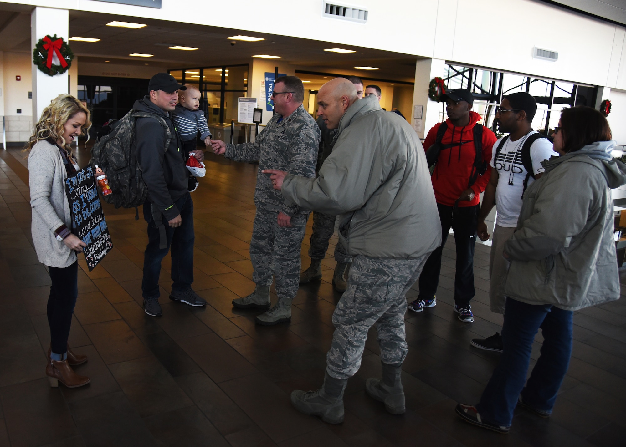 Leadership from the 69th Maintenance Squadron welcome home Airmen from their squadron Dec. 9, 2016, in Grand Forks, N.D. Airmen with the 69th MXS deploy regularly and work to ensure the mission of the 69th Reconnaissance Group is completed at home and abroad. (U.S. Air Force photo by Senior Airman Ryan Sparks)