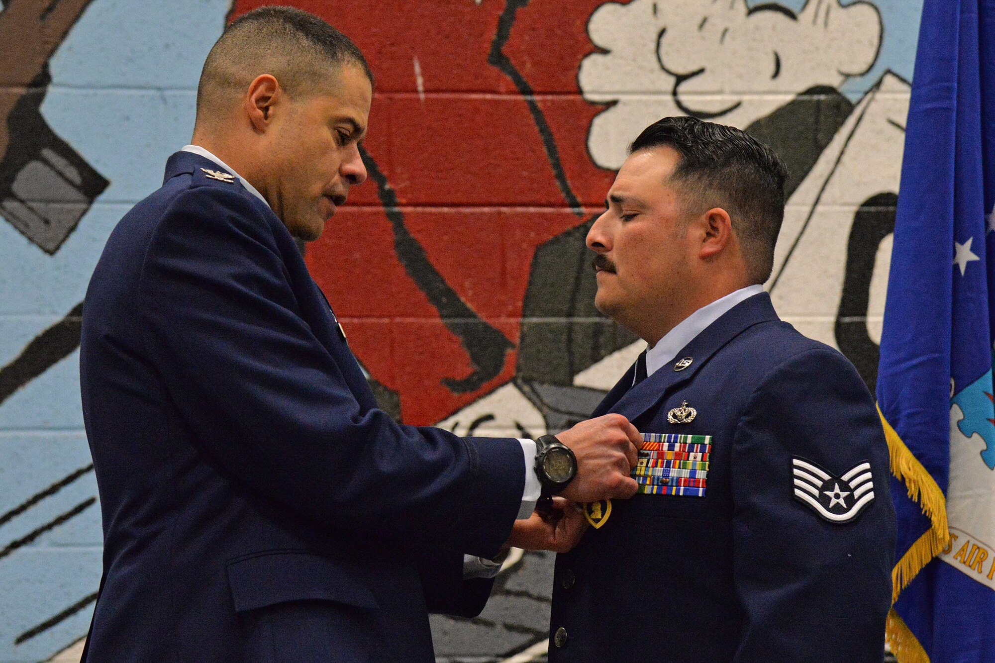 Col. Jose Rivera, 819th RED HORSE Squadron commander, left, pins a Purple Heart medal on Staff Sgt. Joseph Dickison, 819th RHS heating, ventilation and air conditioning technician, during a ceremony at the Air Fields hangar Dec. 9, 2016, at Malmstrom Air Force Base, Mont. Dickison was awarded the Purple Heart for combat wounds received in Afghanistan in July 2009. (U.S. Air Force photo/Airman 1st Class Daniel Brosam)