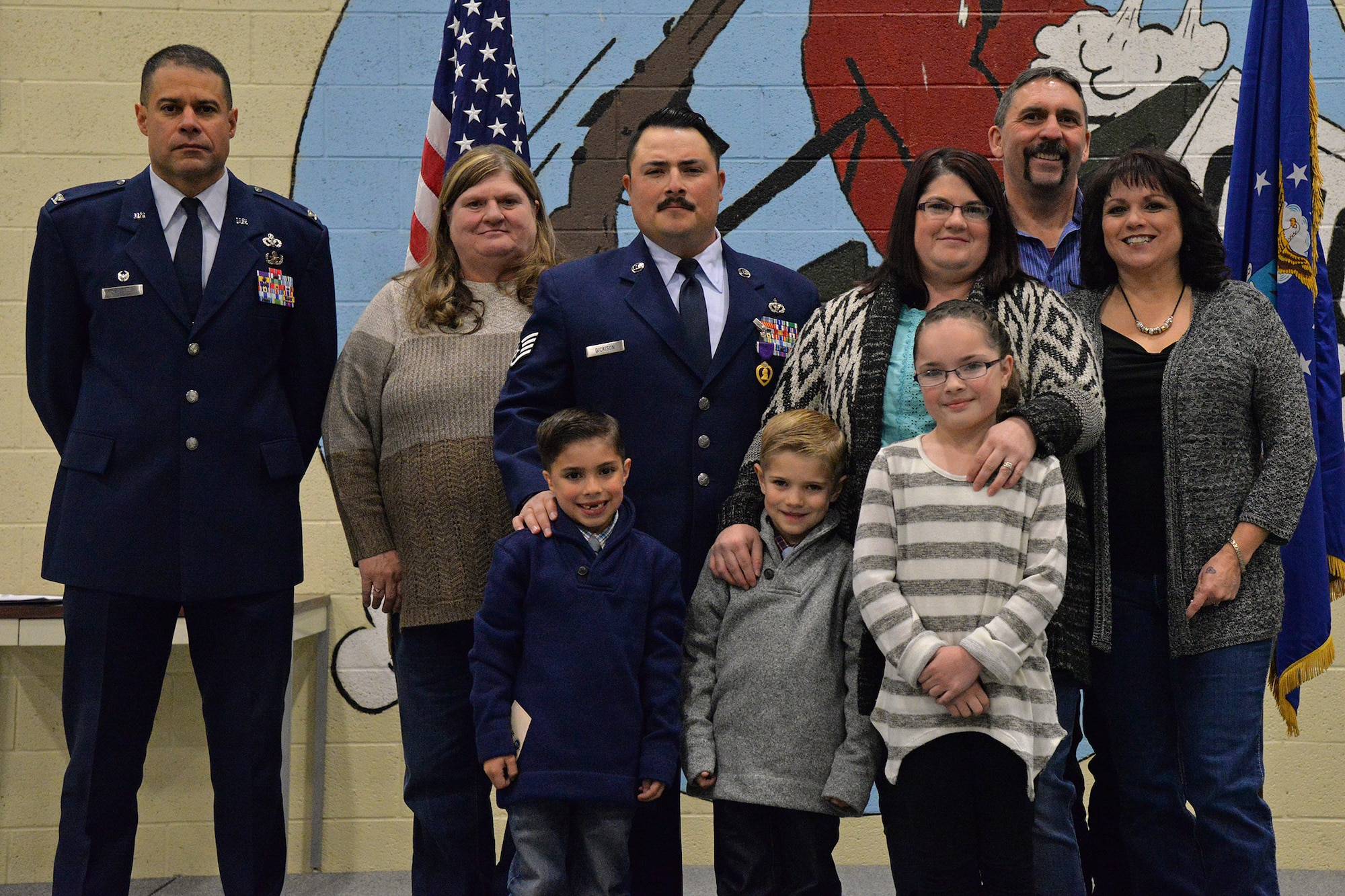 Staff Sgt. Joseph Dickison, 819th RED HORSE Squadron heating, ventilation and air conditioning technician, center, poses with his family and Col. Jose Rivera, 819th RHS commander, after a Purple Heart medal ceremony Dec. 9, 2016, at Malmstrom Air Force Base, Mont. Dickison wants to use this opportunity to spread awareness about the relation between post-traumatic stress disorder and traumatic brain injury and help other people through hard situations where sometimes they may feel they are alone. (U.S. Air Force photo/Airman 1st Class Daniel Brosam)