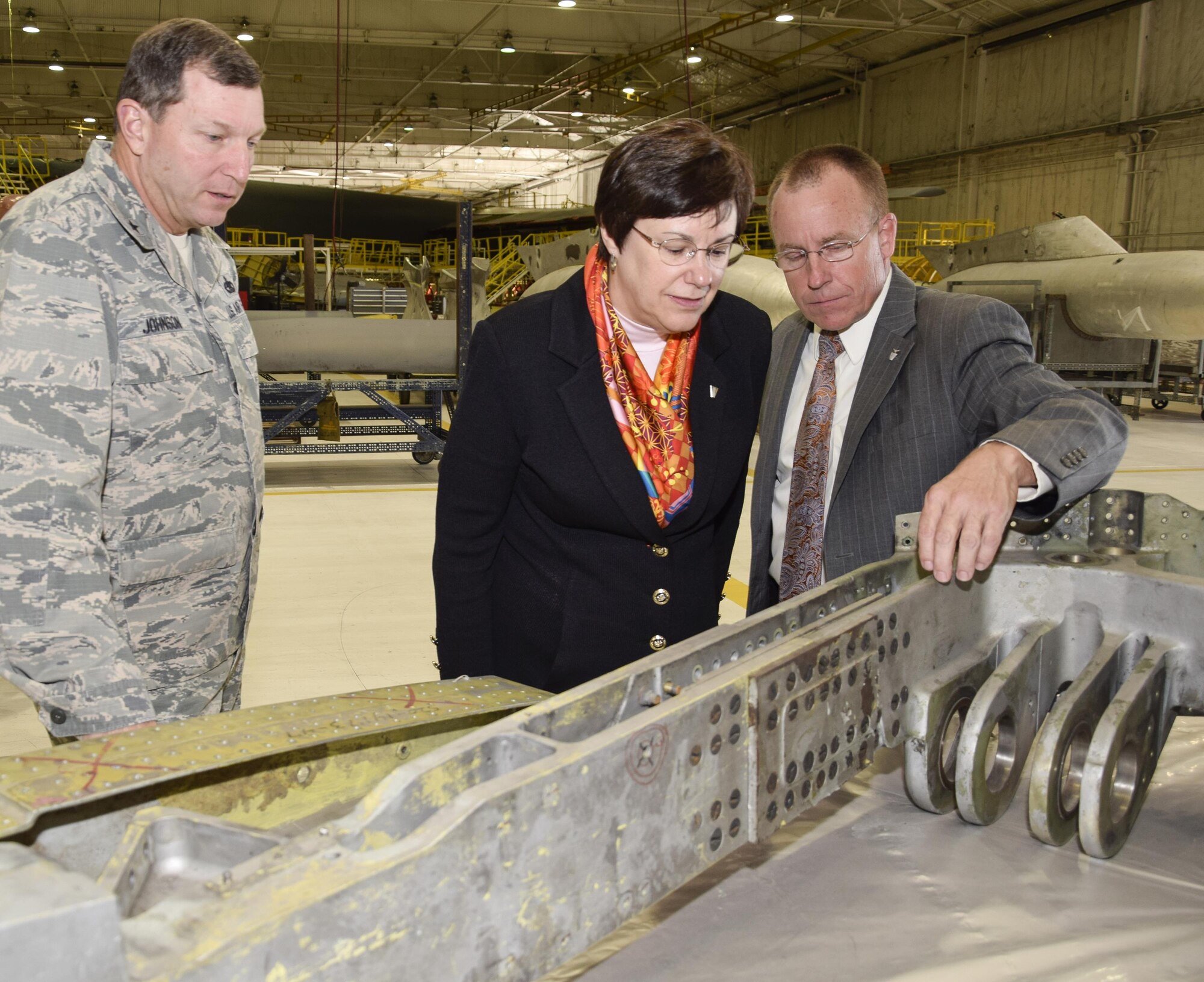 Air Force Materiel Command Executive Director Patricia M. Young (center) looks on as Jeffrey C. Allen, Air Force Sustainment Center executive director (right), points out splice-plates on a B-52 landing gear trunnion during a mission and capabilities tour Nov. 29, 2016, at Tinker Air Force Base, Okla. The briefing was hosted by Brig. Gen. Mark Johnson, Oklahoma City Air Logistics Complex commander (left), and demonstrated aging aircraft maintenance challenges. During her visit, Young toured the Air Force Sustainment Center, Oklahoma City Air Logistics Complex and 72nd Air Base Wing to learn about the maintenance, repair and overhaul workload accomplished at Tinker. (U.S. Air Force photo/Greg L. Davis)