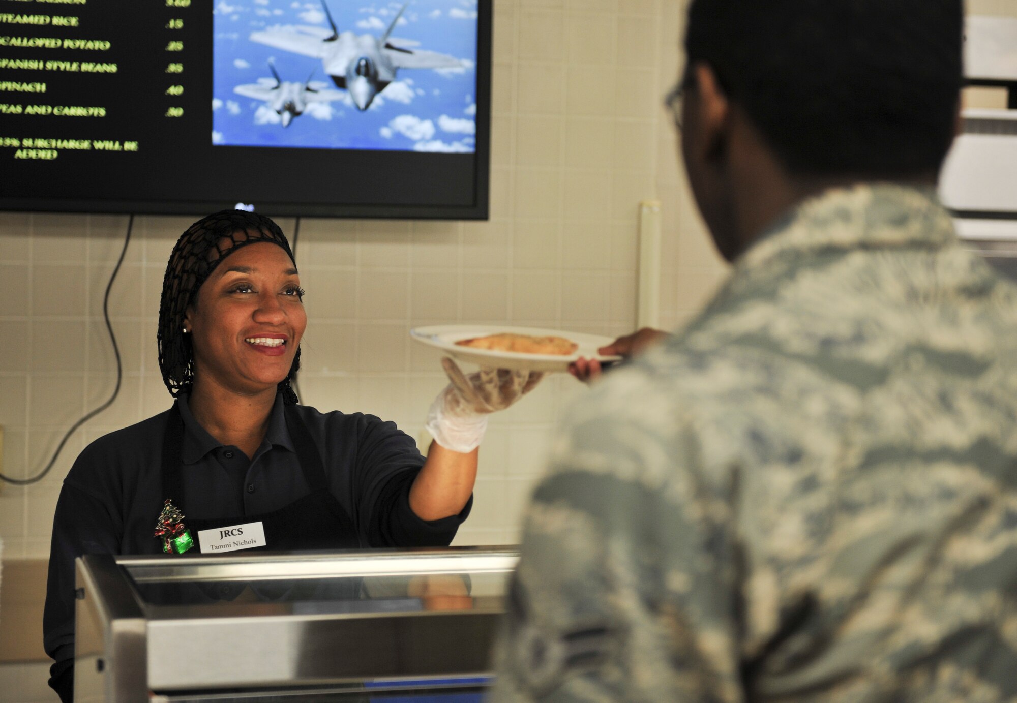 Tammi Nichols, 325th Force Support Squadron food service assistant, prepares a plate for an Airman at the Berg-Lilles Dining Facility at Tyndall Air Force Base, Fla., Dec. 9, 2016. The 325th FSS is tasked with providing essential services to more than 800 personnel during Checkered Flag17-1/Combat Archer 17-1. (U.S. Air force photo by Senior Airman Dustin Mullen/Released)